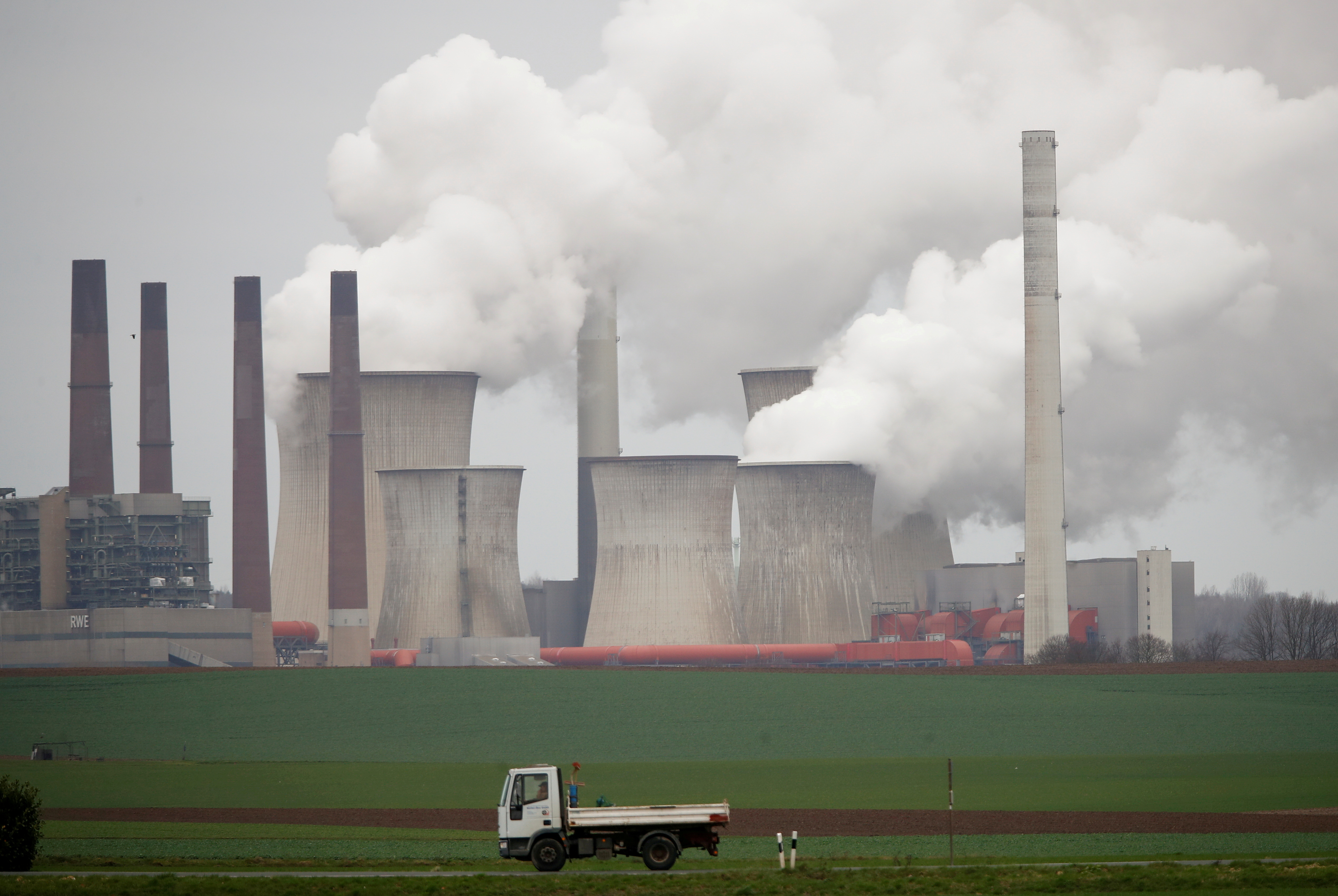 A truck drives by as steam rises from the five brown coal-fired power units of RWE, one of Europe's biggest electricity companies in Neurath, north-west of Cologne, Germany, Germany, March 12, 2019.   REUTERS/Wolfgang Rattay 