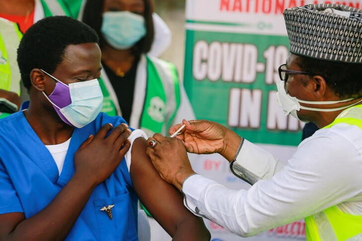 Ο Δρ Ngong Cyprian λαμβάνει την πρώτη του δόση του εμβολίου για την ασθένεια του κορωνοϊού Oxford/AstraZeneca (COVID-19) από τον Δρ Faisal Shuaib, Εκτελεστικό Διευθυντή και Διευθύνοντα Σύμβουλο της Εθνικής Υπηρεσίας Ανάπτυξης Πρωτοβάθμιας Φροντίδας Υγείας, στο Εθνικό νοσοκομείο της Abuja της Νιγηρίας, Μάρτιος 5, 2021. REUTERS/Afolabi Sotunde
