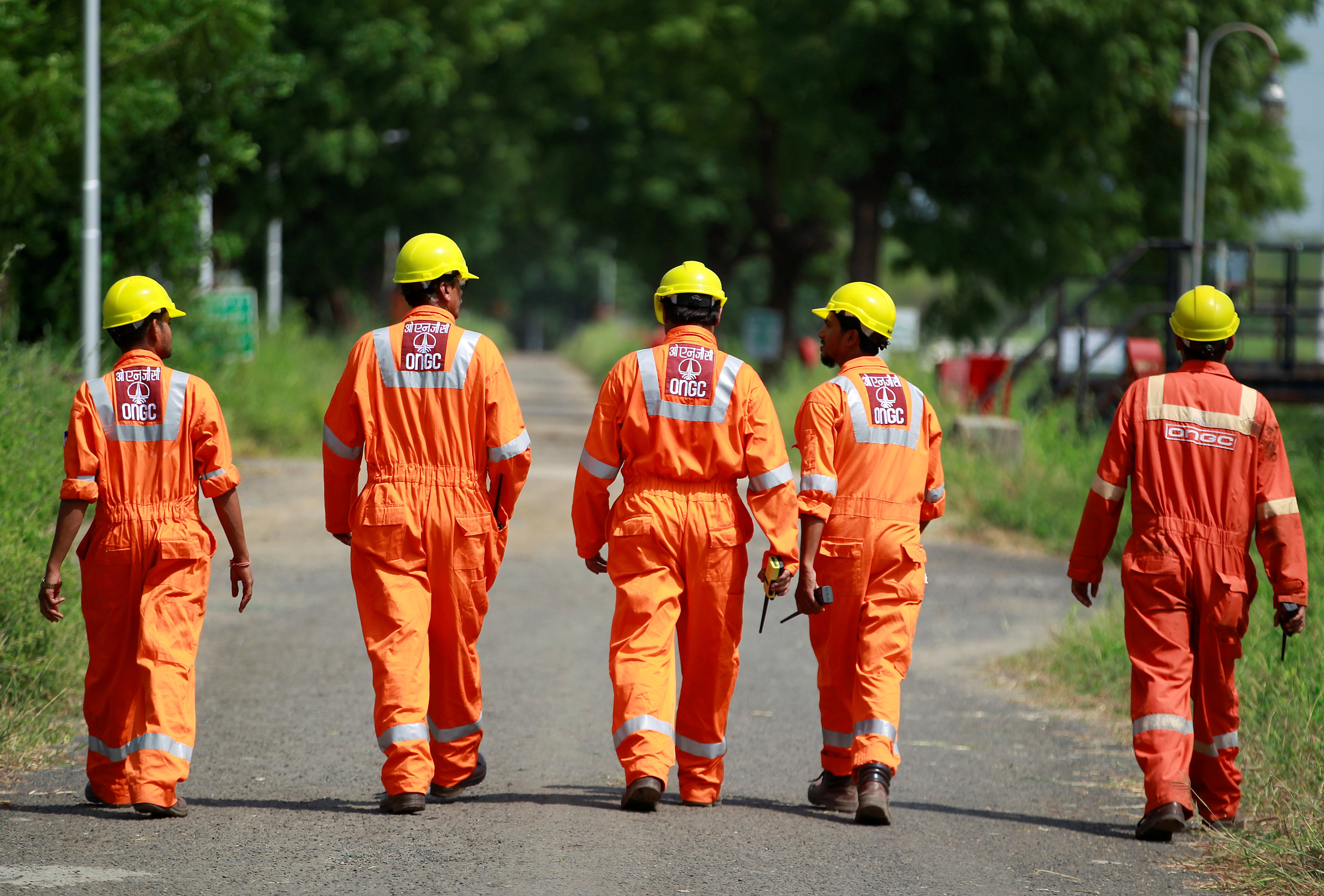 Technicians walk inside the Oil and Natural Gas Corp (ONGC) group gathering station on the outskirts of Ahmedabad