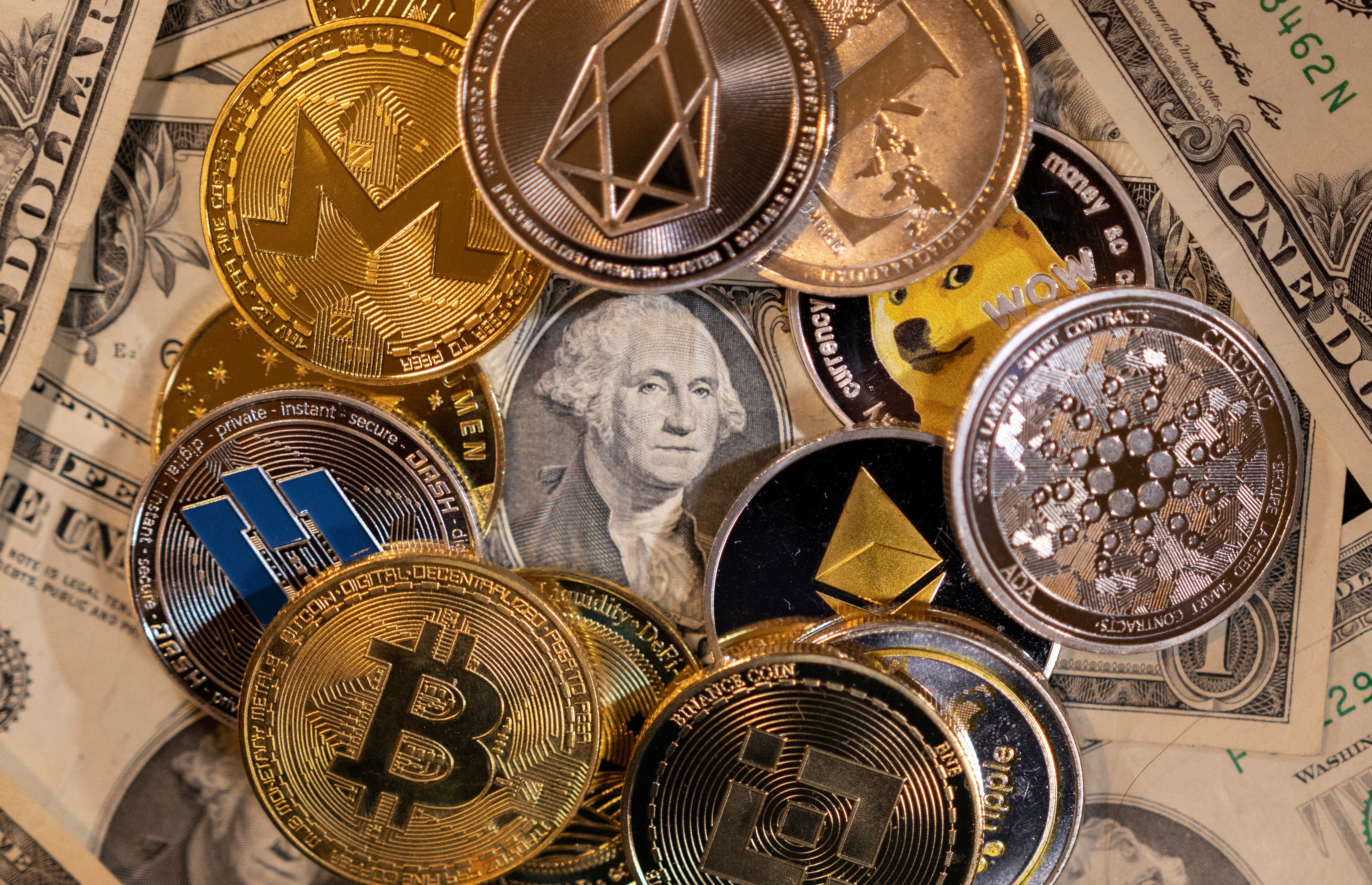 Ilustration shows representations of virtual cryptocurrencies on U.S. Dollar banknotes