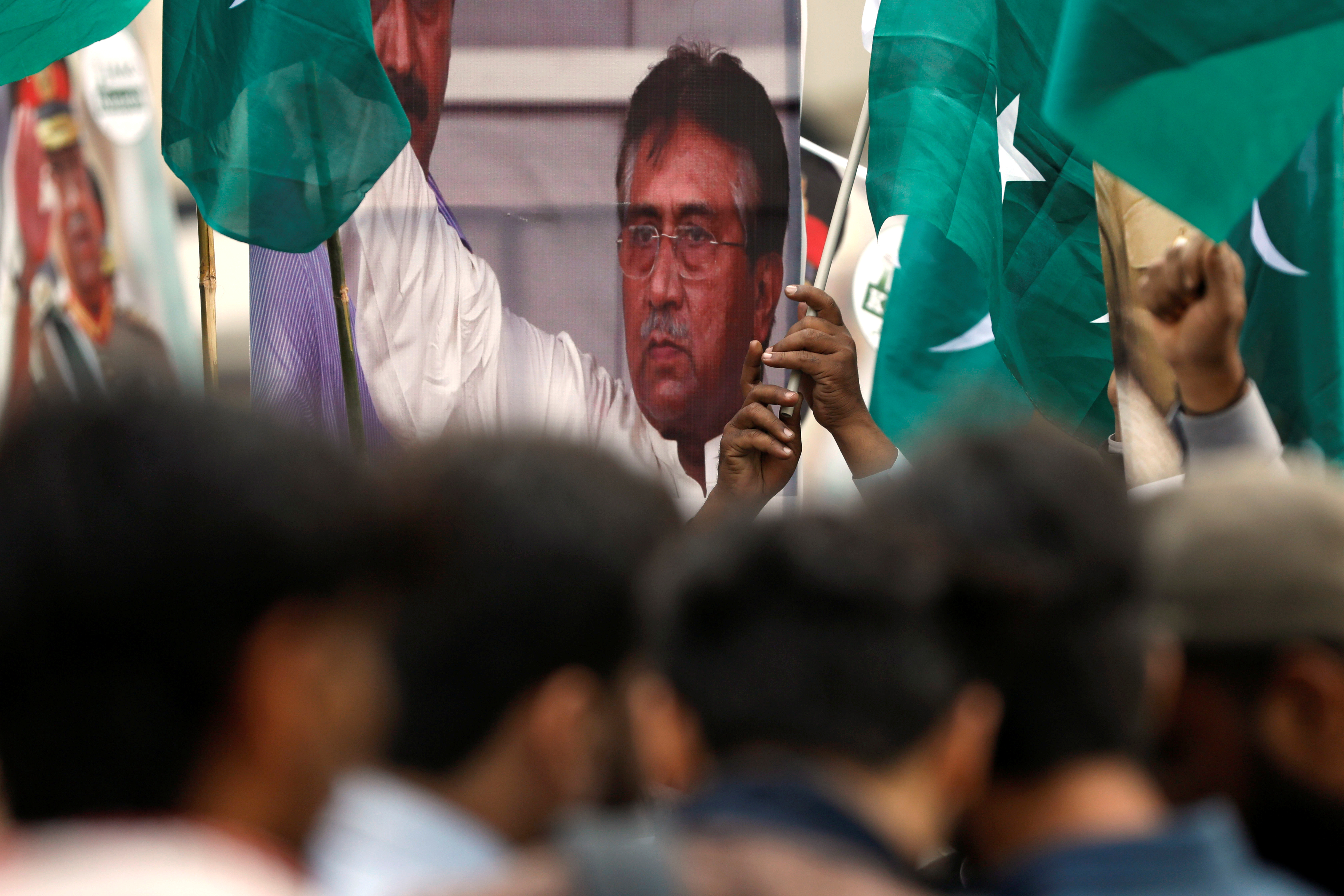 Supporters of Pervez Musharraf carry national flags and signs, after a Pakistani court sentenced the former military ruler to death on charges of high treason and subverting the constitution, during a protest in Karachi,