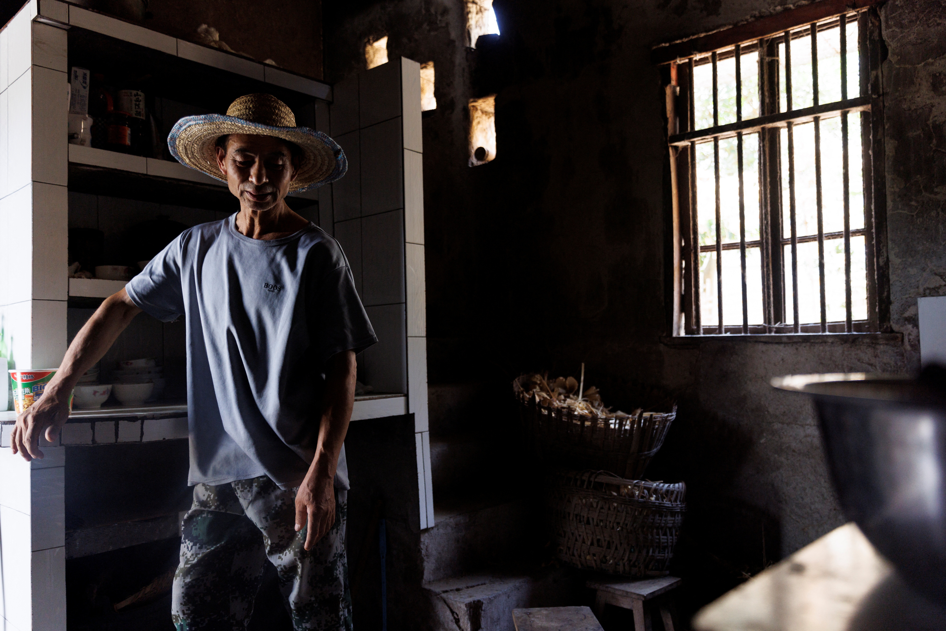 Local farmer Chen Xiaohua, 68, stands in his house where the water has been turned off as the region is experiencing a drought in Fuyuan village in Chongqing