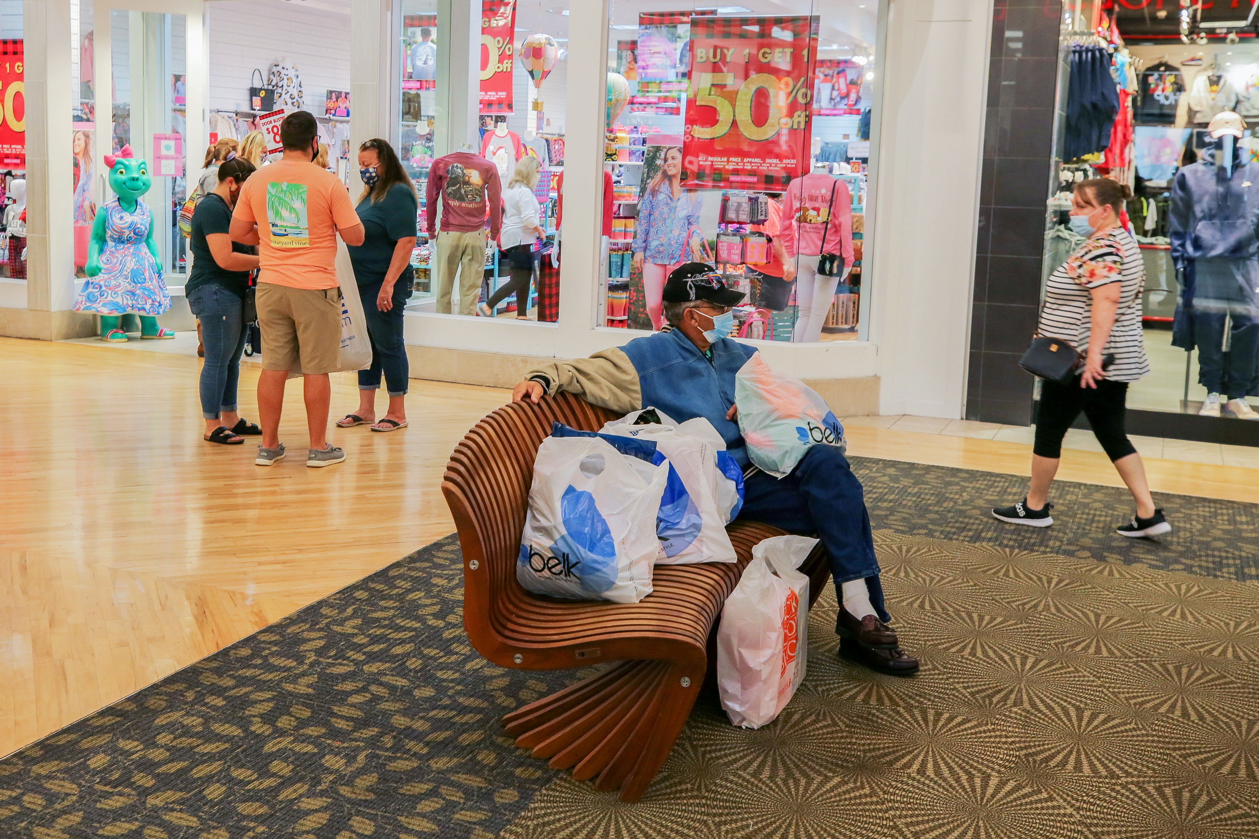 A man sits with several bags at Coastal Grand Mall on Black Friday, as the coronavirus disease (COVID-19) pandemic continues, in Myrtle Beach, South Carolina, U.S., November 27, 2020.  REUTERS/Micah Green/File Photo