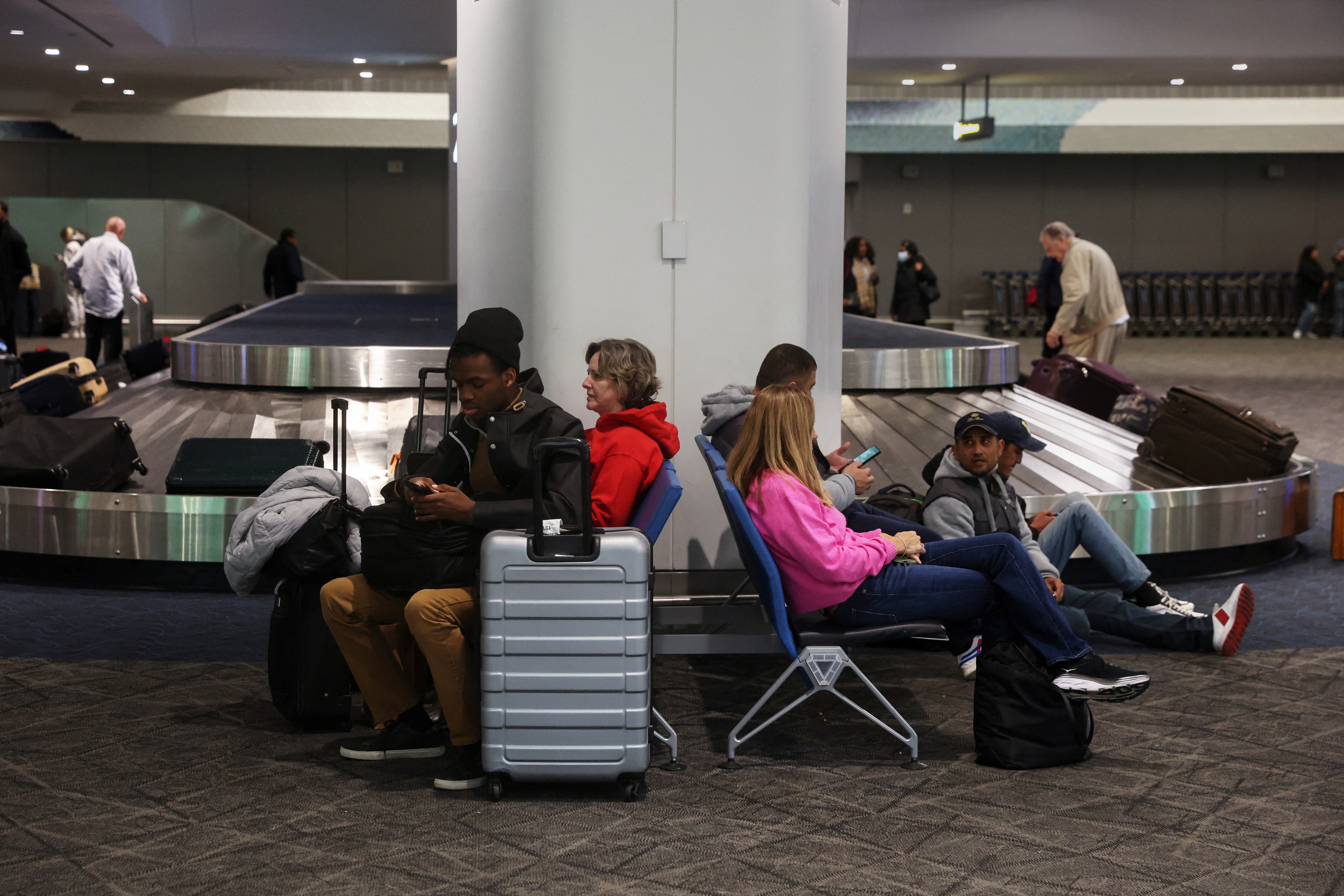 Travelers wait for luggage, as people begin to travel ahead of the Thanksgiving holiday, at LaGuardia Airport in New York City