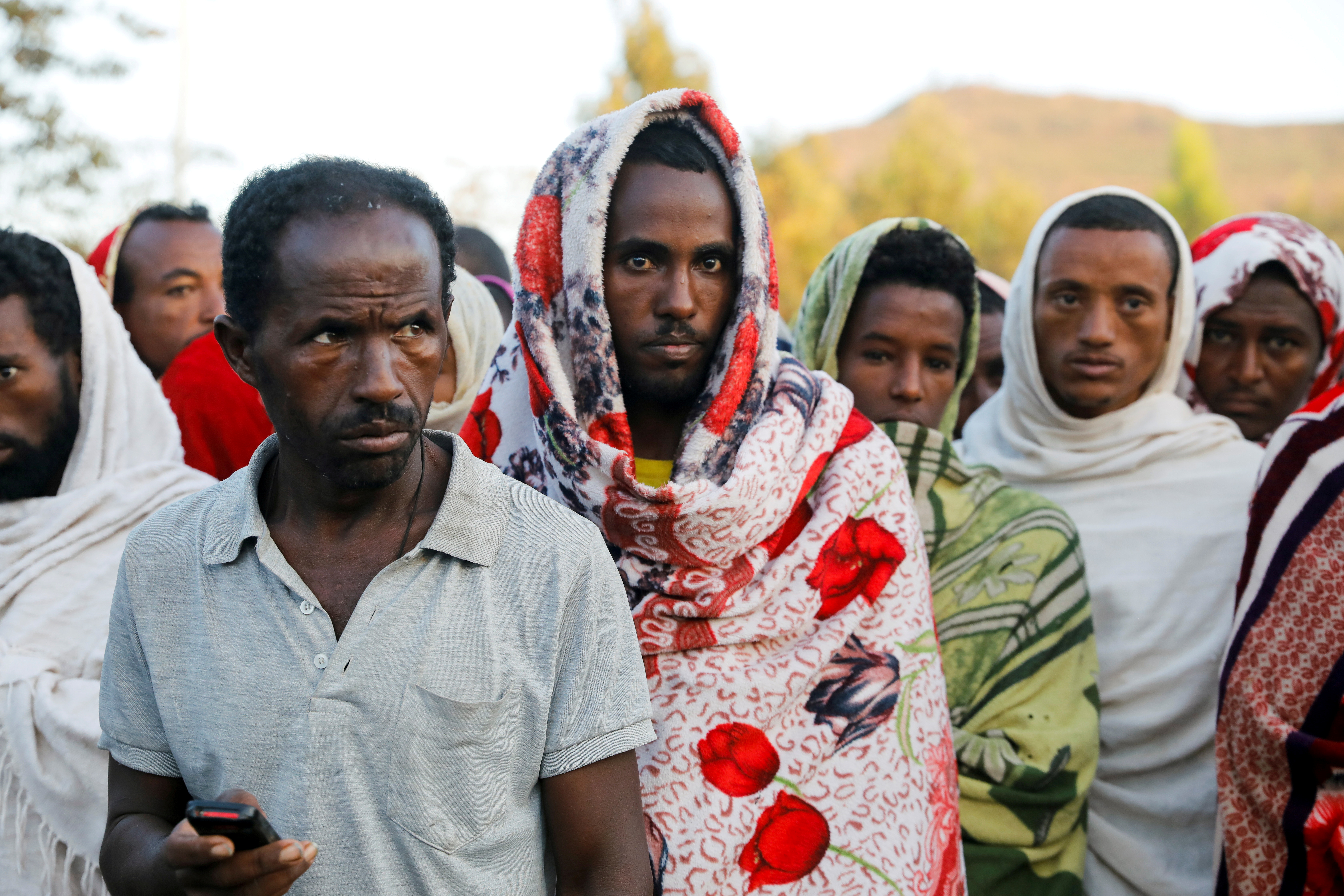 Men stand in line to receive food donations, at the Tsehaye primary school, in Shire