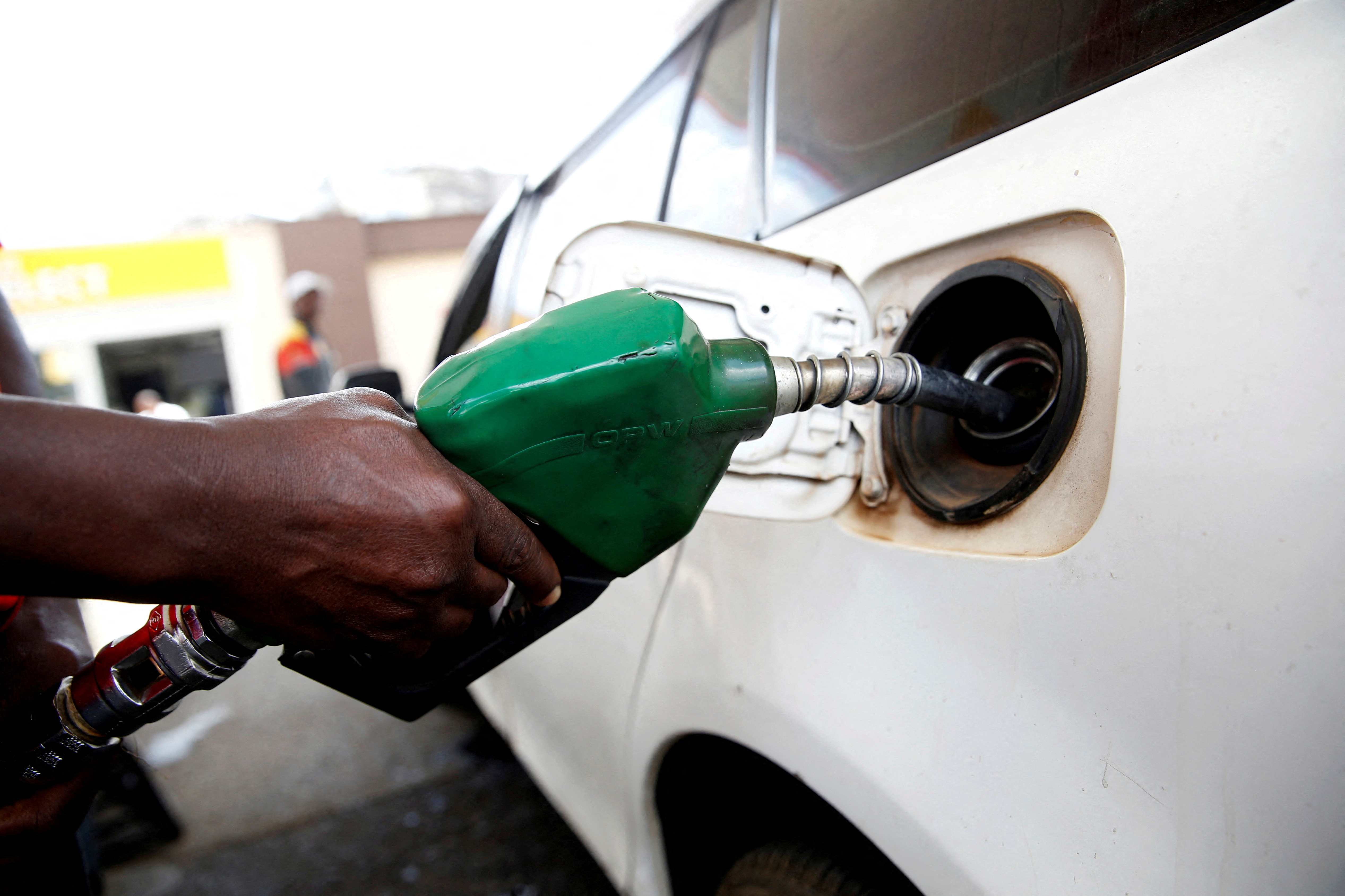 An employee pumps fuel into a car at a Shell petrol station in Nairobi