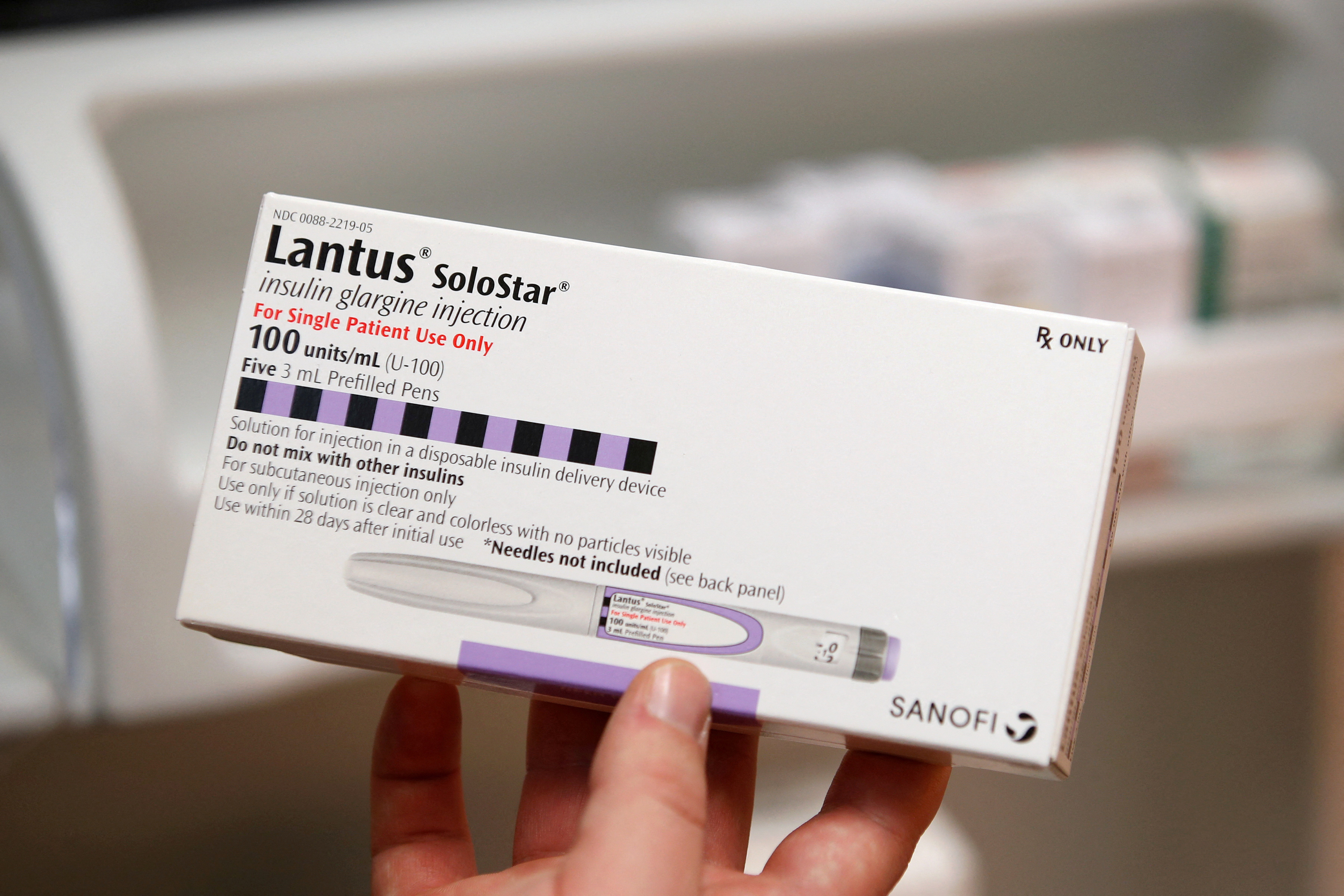 A pharmacist holds a box of the drug Lantus SoloStar, made by Sanofi Pharmaceutical, at a pharmacy in Provo