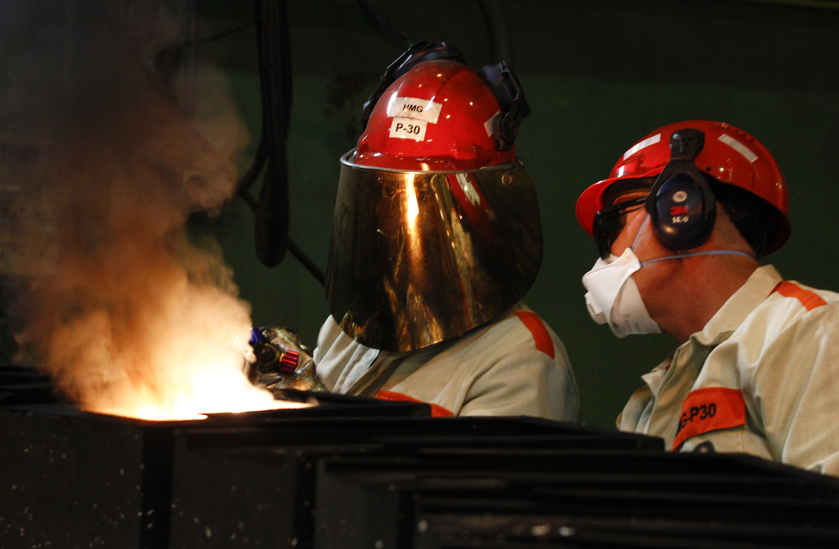 Workers prepare to pour molten silver into moulds at the KGHM copper and precious metals smelter processing plant in Glogow