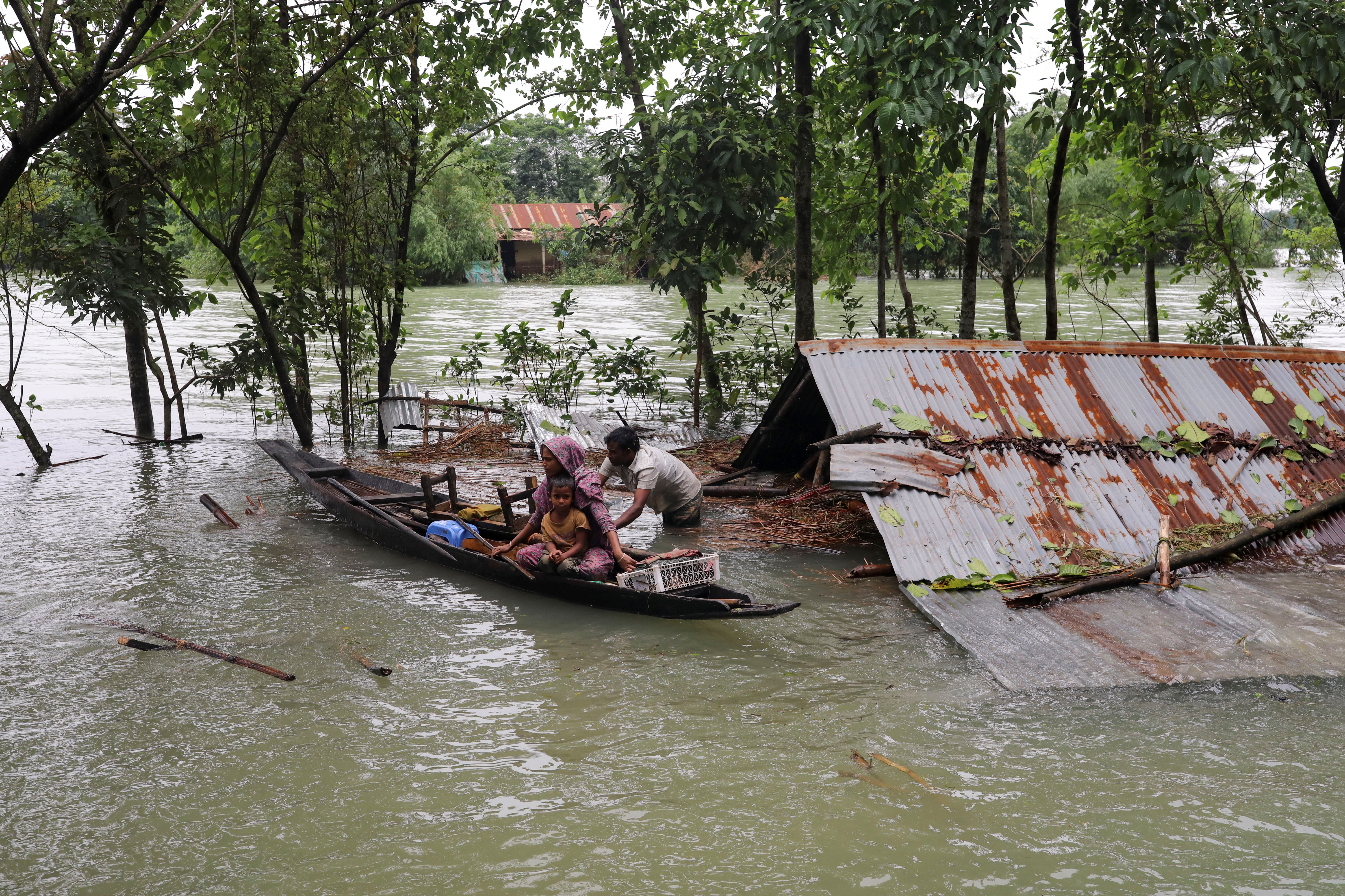 People get on a boat as they look for shelter during a widespread flood in Sylhet