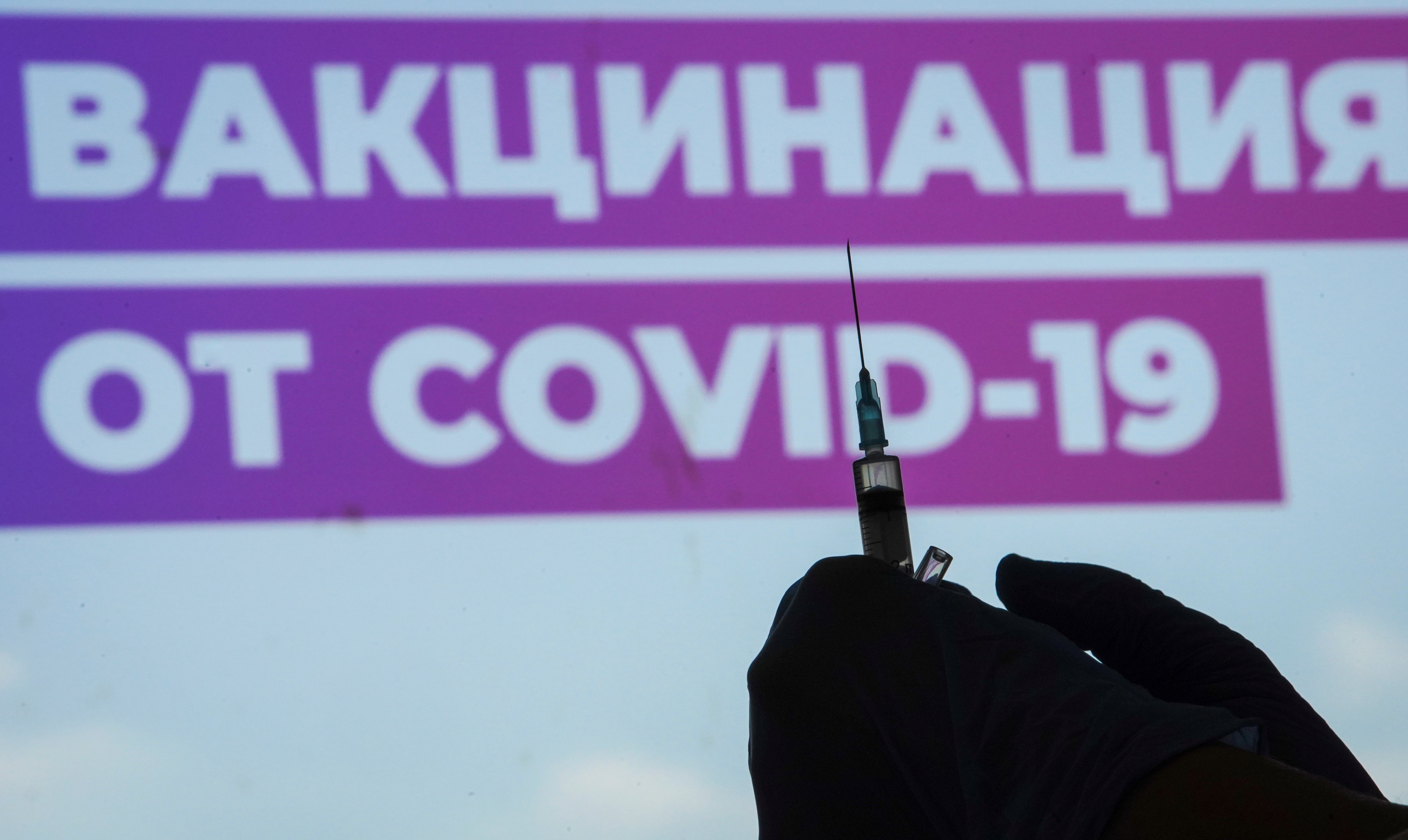 A healthcare worker prepares a one-dose Sputnik Light vaccine against the coronavirus disease (COVID-19) at a vaccination centre in Luzhniki Stadium in Moscow, Russia July 8, 2021. A sign reads Vaccination against COVID-19.  REUTERS/Tatyana Makeyeva
