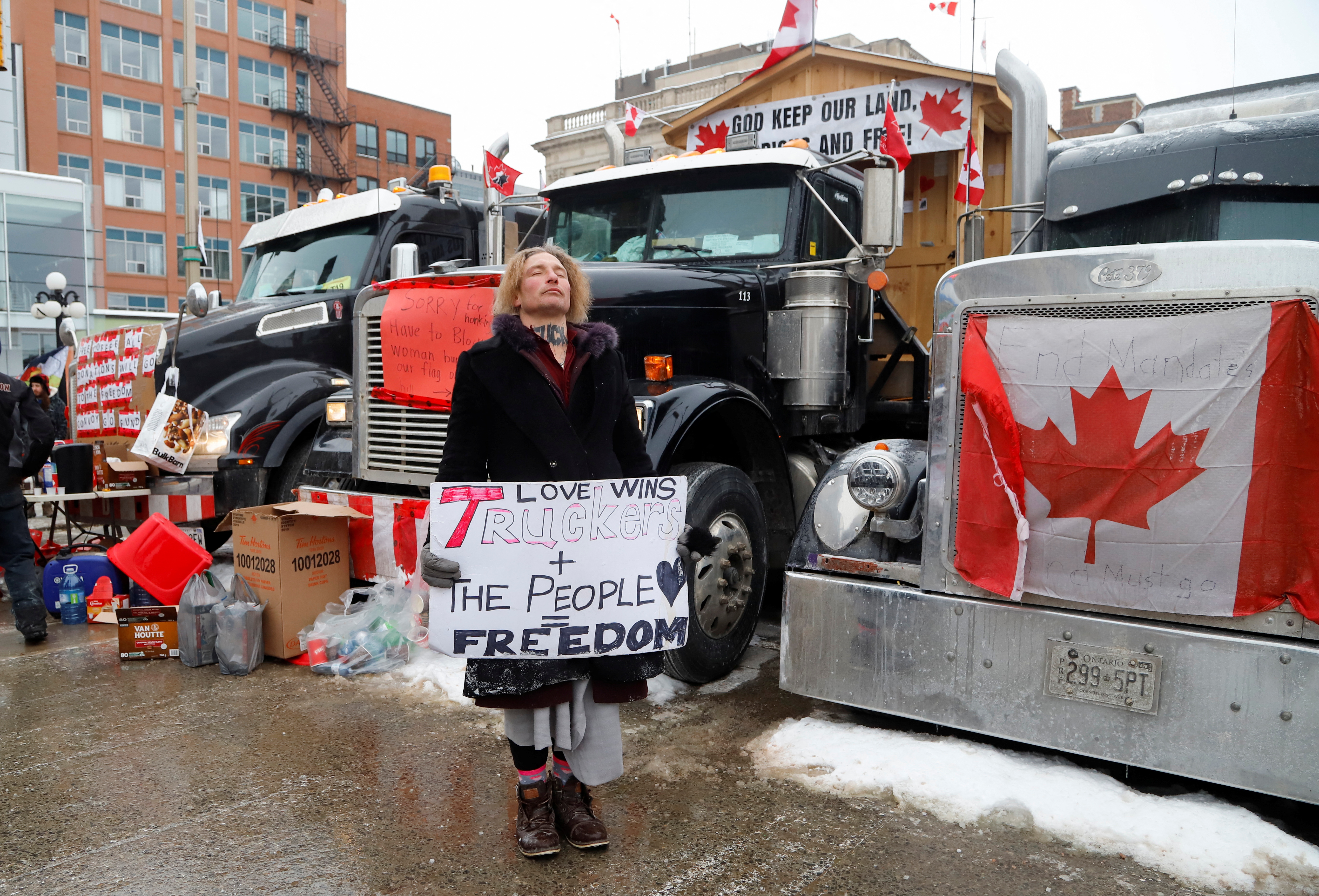 A person hold a sign as truckers and supporters continue to protest coronavirus disease (COVID-19) vaccine mandates, in Ottawa, Ontario, Canada February 3, 2022.  REUTERS/Patrick Doyle
