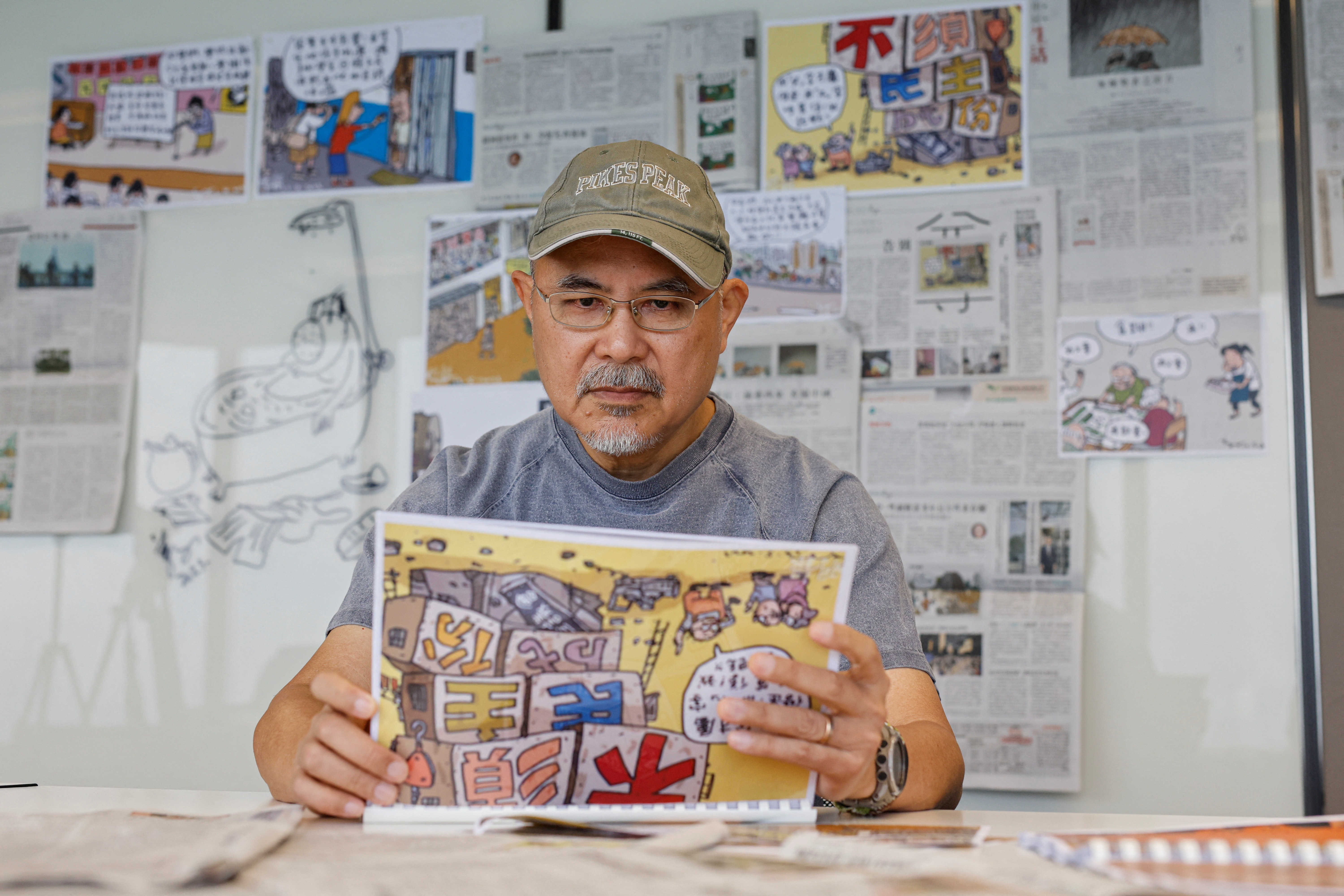 Cartoonist Wong Kei-kwan, who uses the pen name Zunzi, poses for photos after his comic strip has been scrapped from the local newspaper Ming Pao in Hong Kong