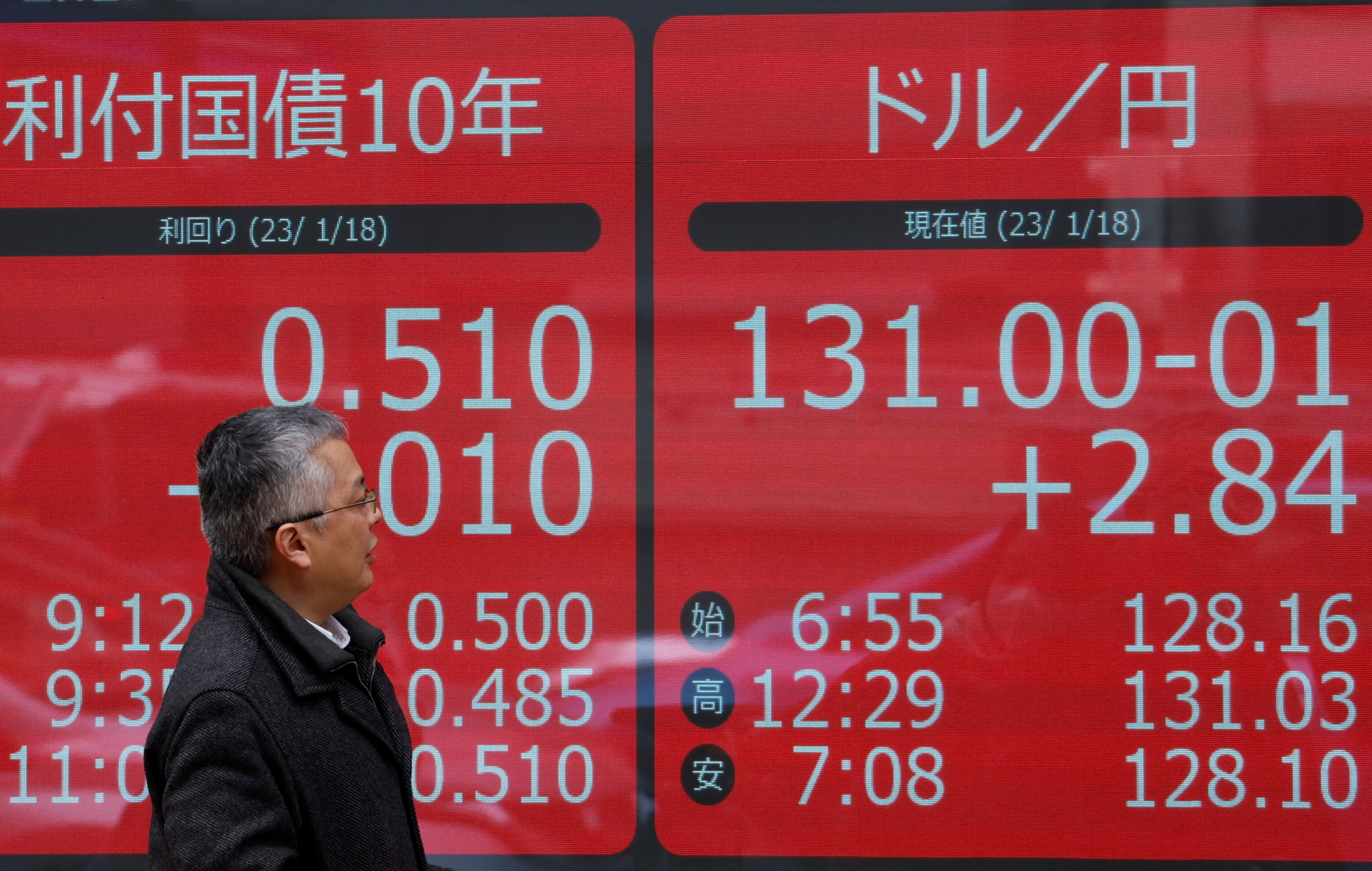 Một người đàn ông nhìn vào màn hình điện hiển thị lãi suất trái phiếu chính phủ 10 năm của Nhật Bản đối với lợn nái hậu bị và tỷ giá hối đoái giữa đồng yên Nhật so với đồng đô la Mỹ bên ngoài một công ty môi giới ở Tokyo