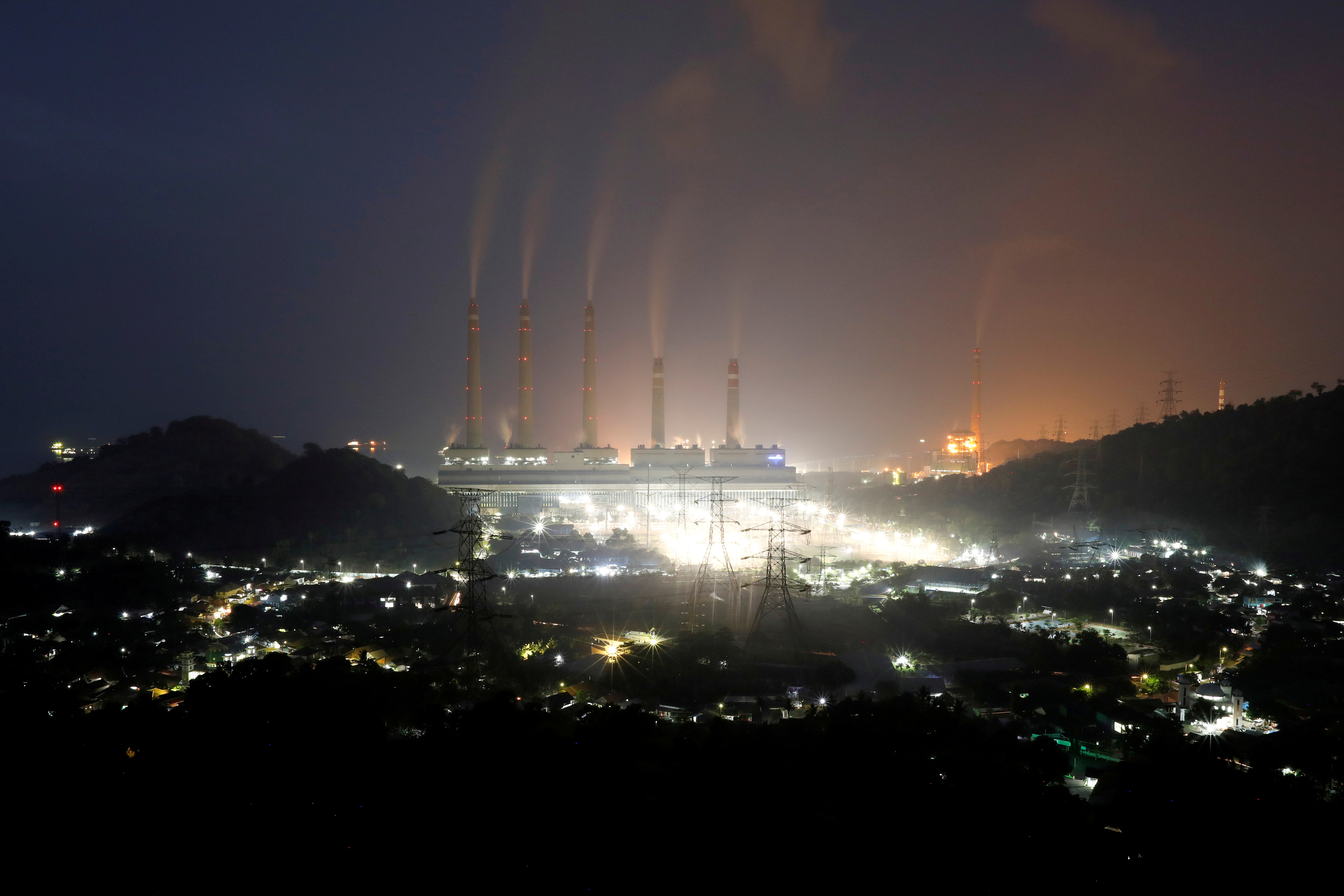 Smoke and steam billows from a coal-fired power plant owned by Indonesia Power in Suralaya