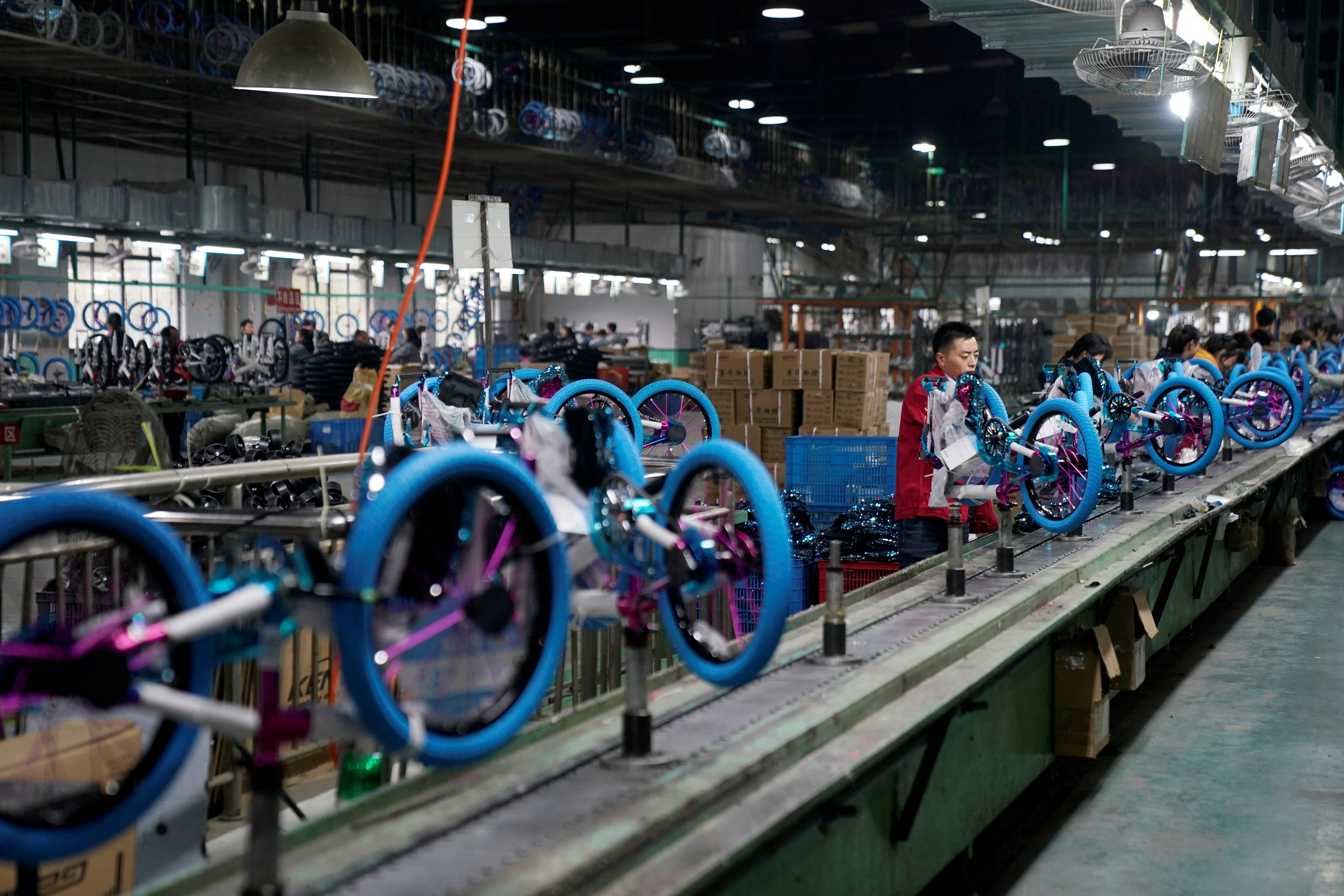 Employees work on the production line of Kent bicycles at Shanghai General Sports Co., Ltd, in Kunshan