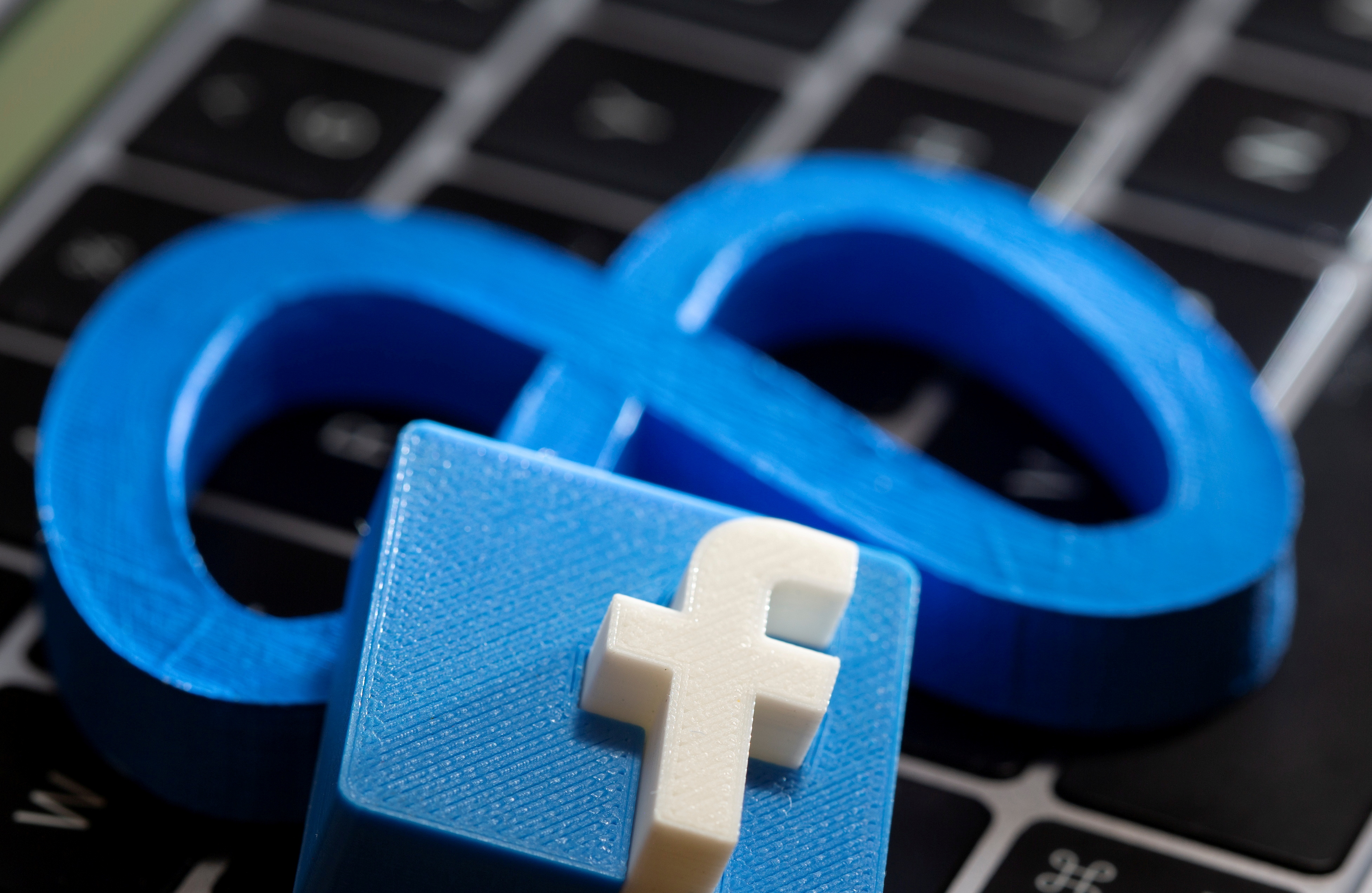 A 3D printed Facebook's new rebrand logo Meta and Facebook logo are placed on laptop keyboard in this illustration taken on November 2, 2021. REUTERS/Dado Ruvic/Illustration/File Photo