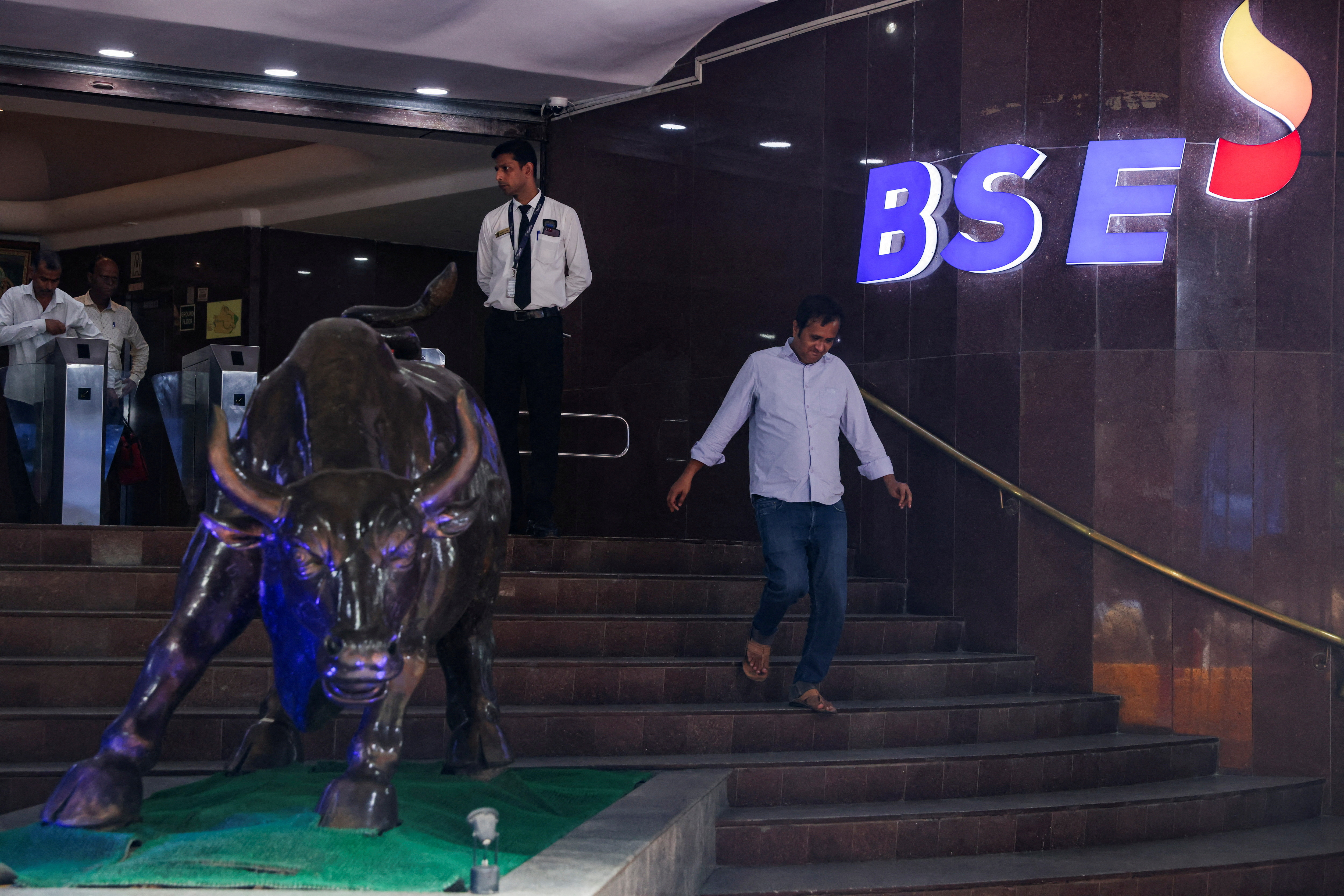 A man walks past the logo of the Bombay Stock Exchange (BSE) building in Mumbai