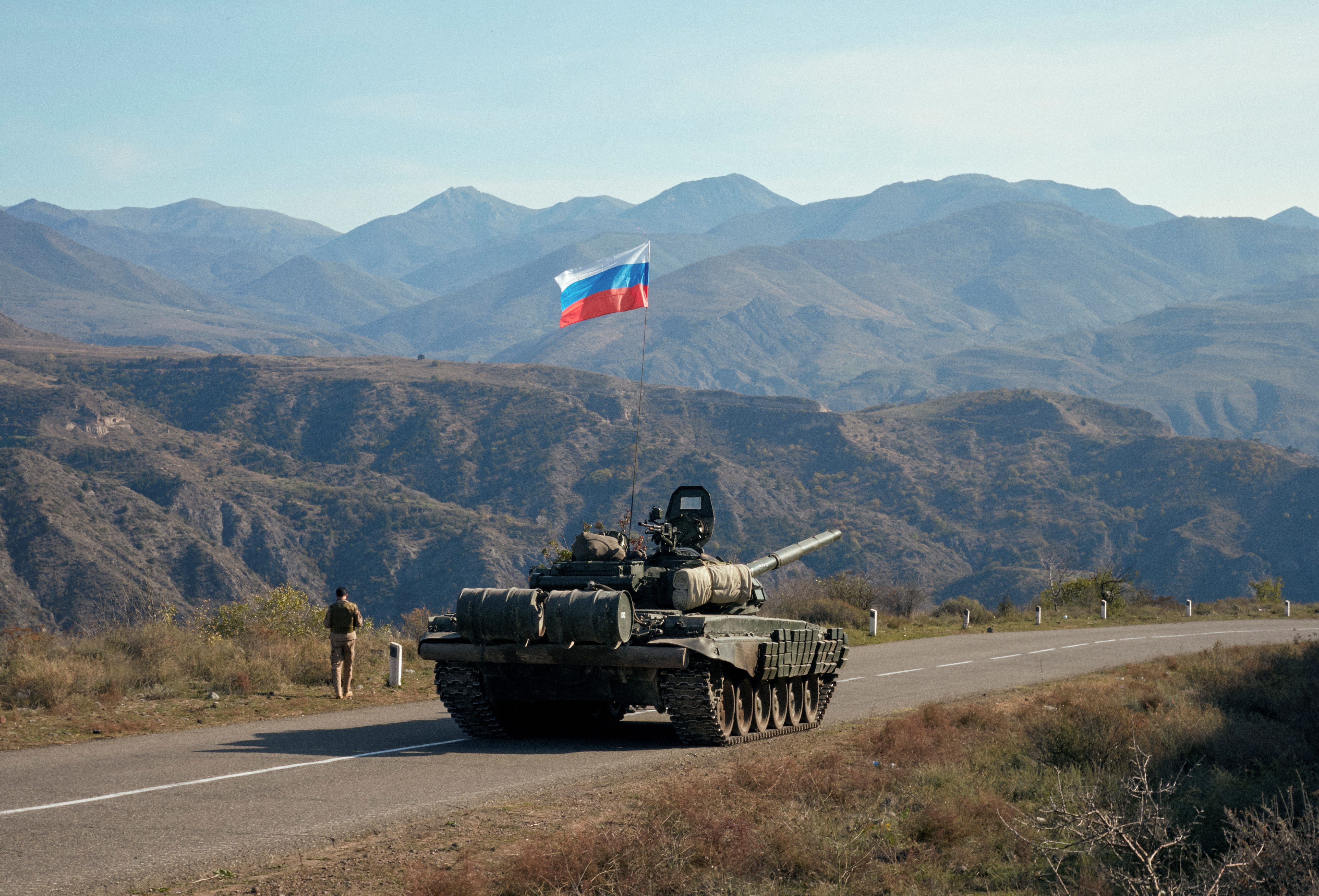 A service member of the Russian peacekeeping troops walks near a tank in Nagorno-Karabakh