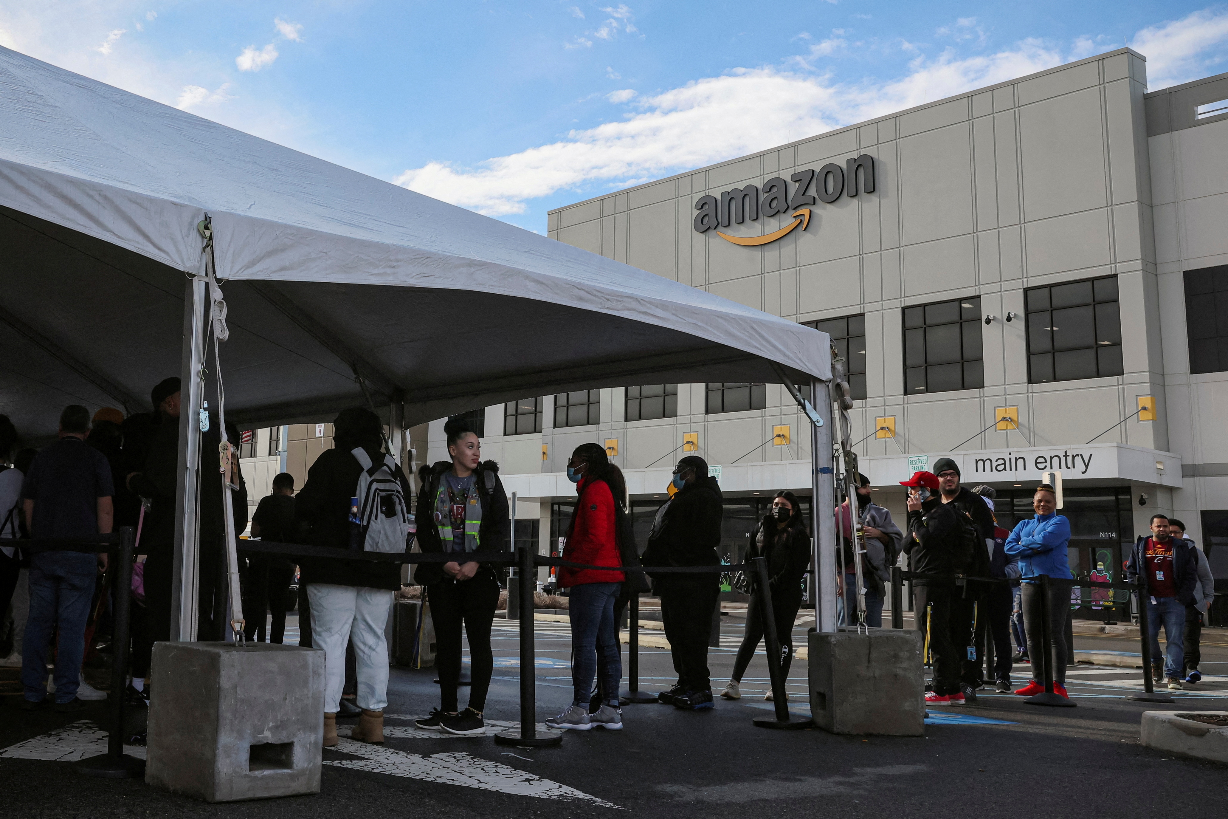 Workers stand in line to cast ballots for a union election at Amazon's JFK8 distribution center, in Staten Island, New York City