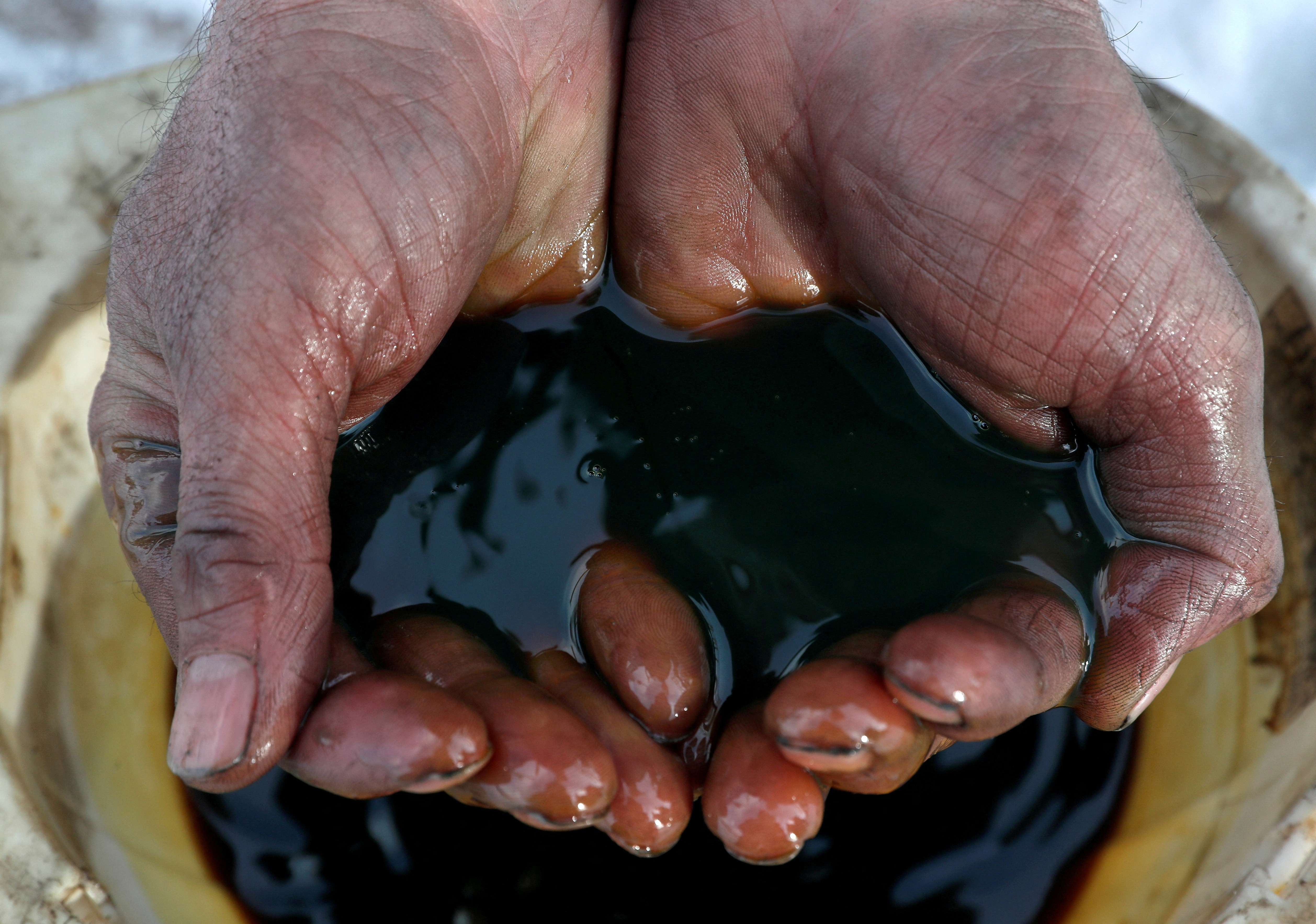 An employee holds a sample of crude oil at the Irkutsk Oil Co-owned Yarakta field in the Irkutsk region