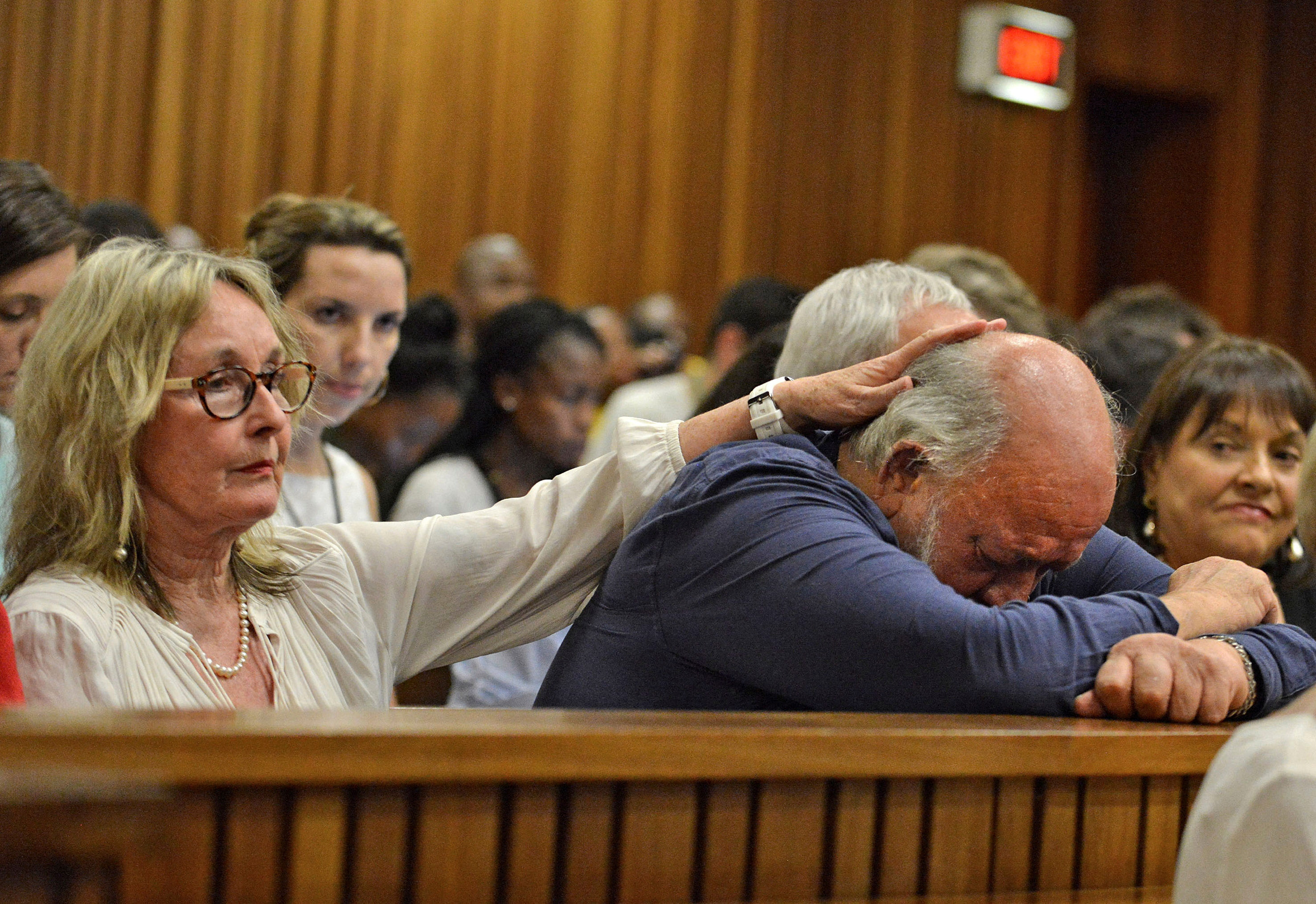 Barry Steenkamp is consoled by his wife during the sentencing hearing of Pistorius at the North Gauteng High Court in Pretoria