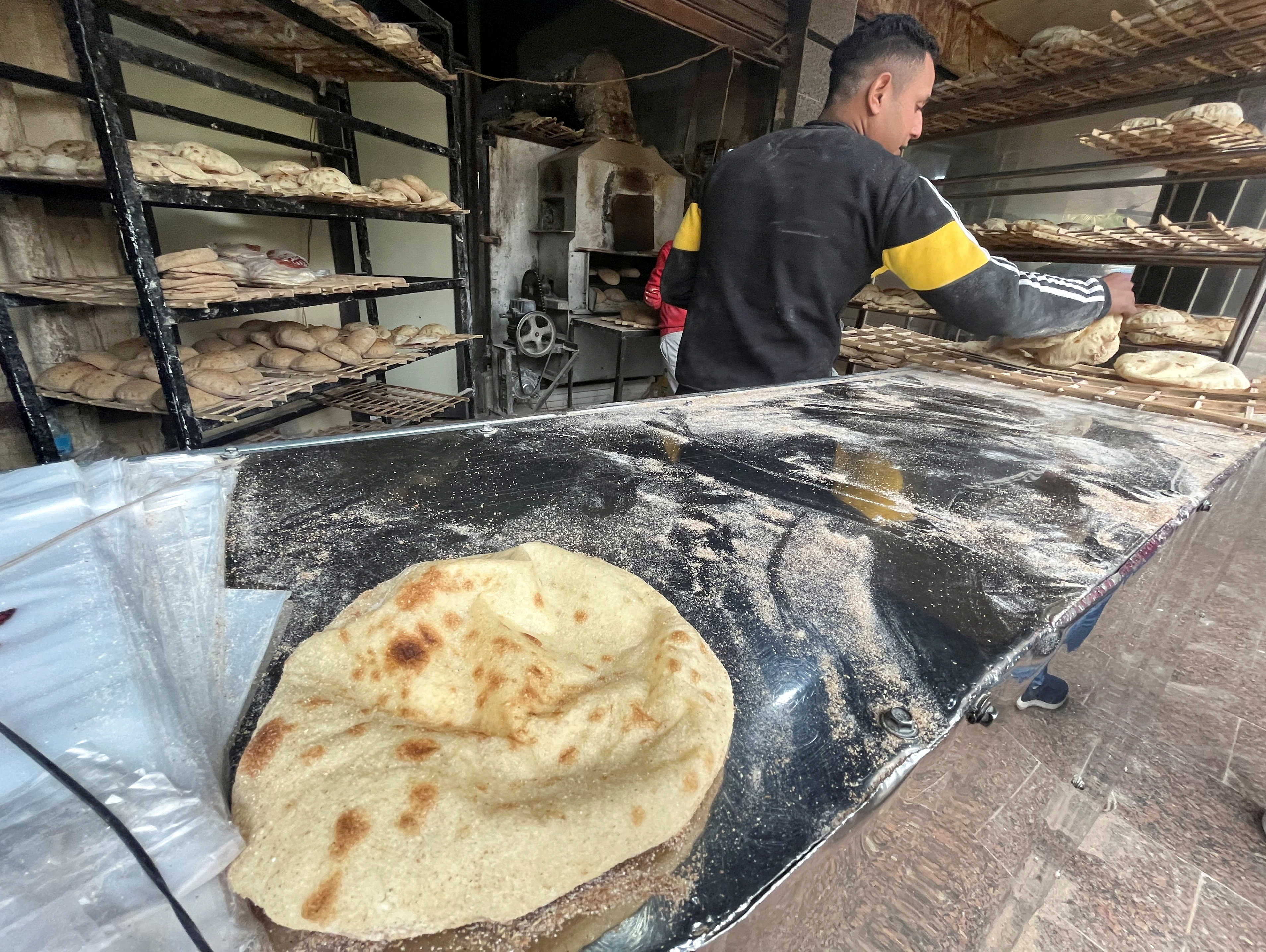 A man sells bread inside a bakery in Maadi, a suburb of Cairo