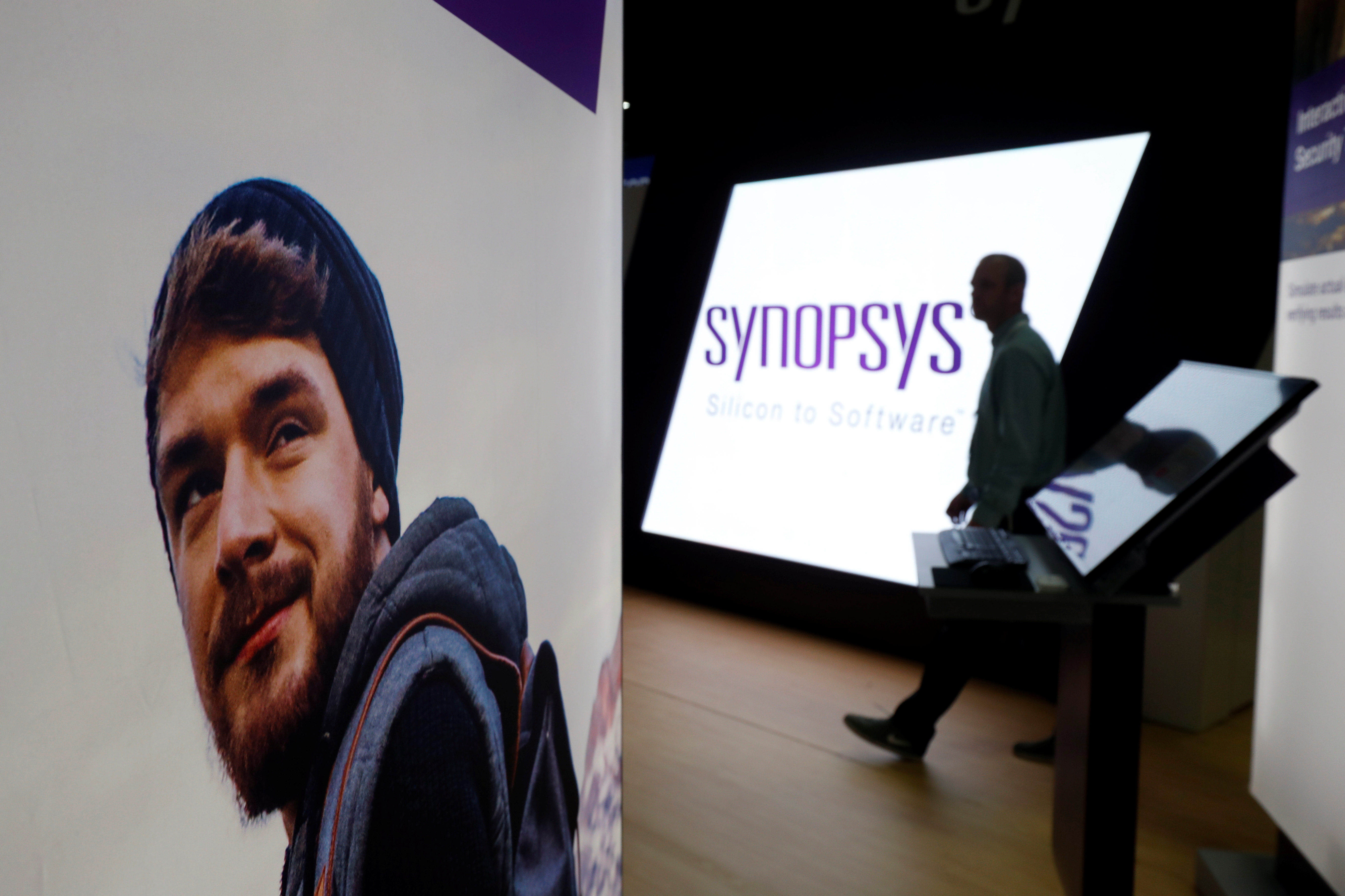 A man walks through the Synopsys booth during the Black Hat information security conference in Las Vegas