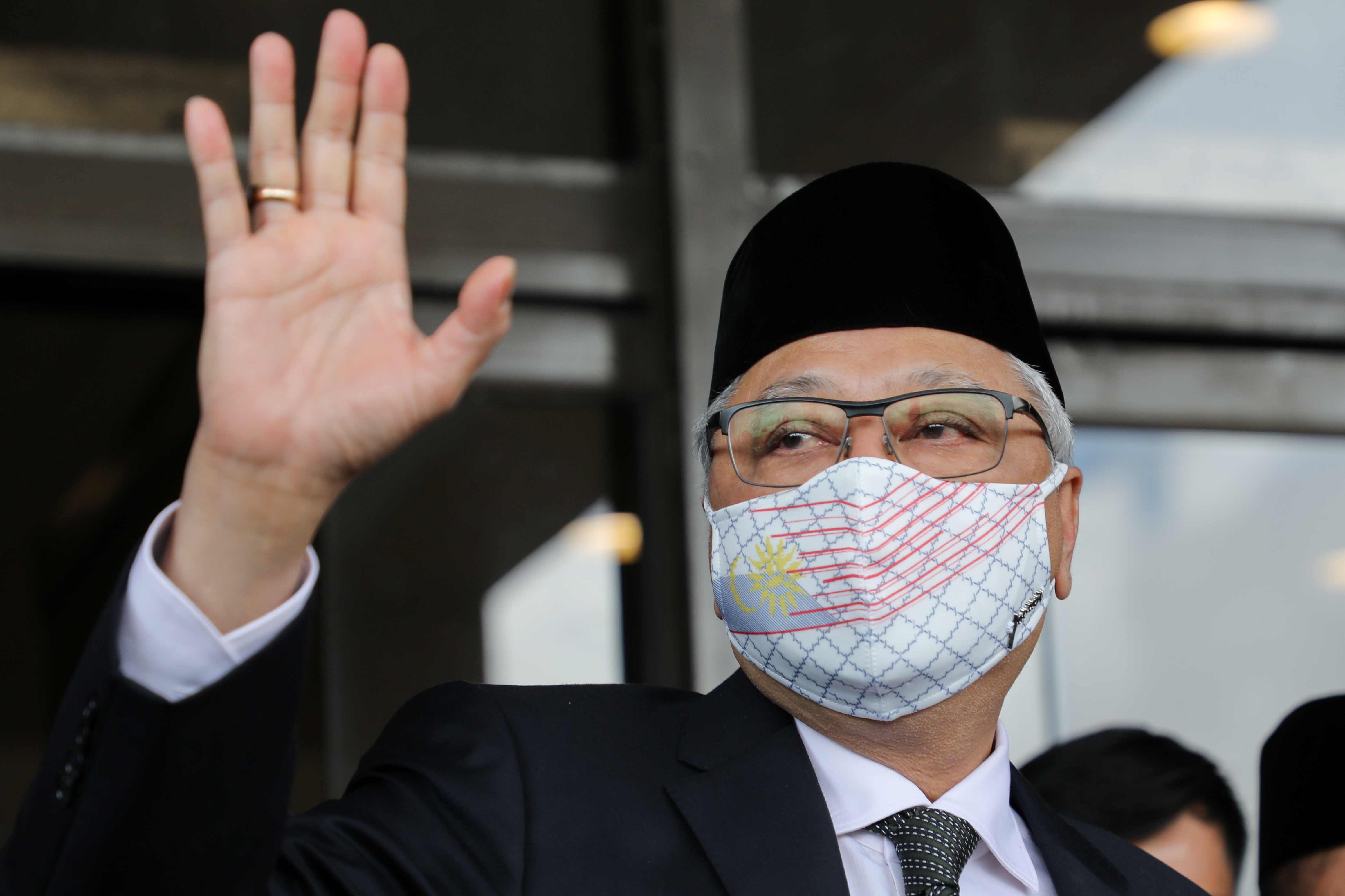 Former Malaysian Deputy Prime Minister Ismail Sabri Yaakob waves to members of the media before departing for a meeting with the King, in Kuala Lumpur