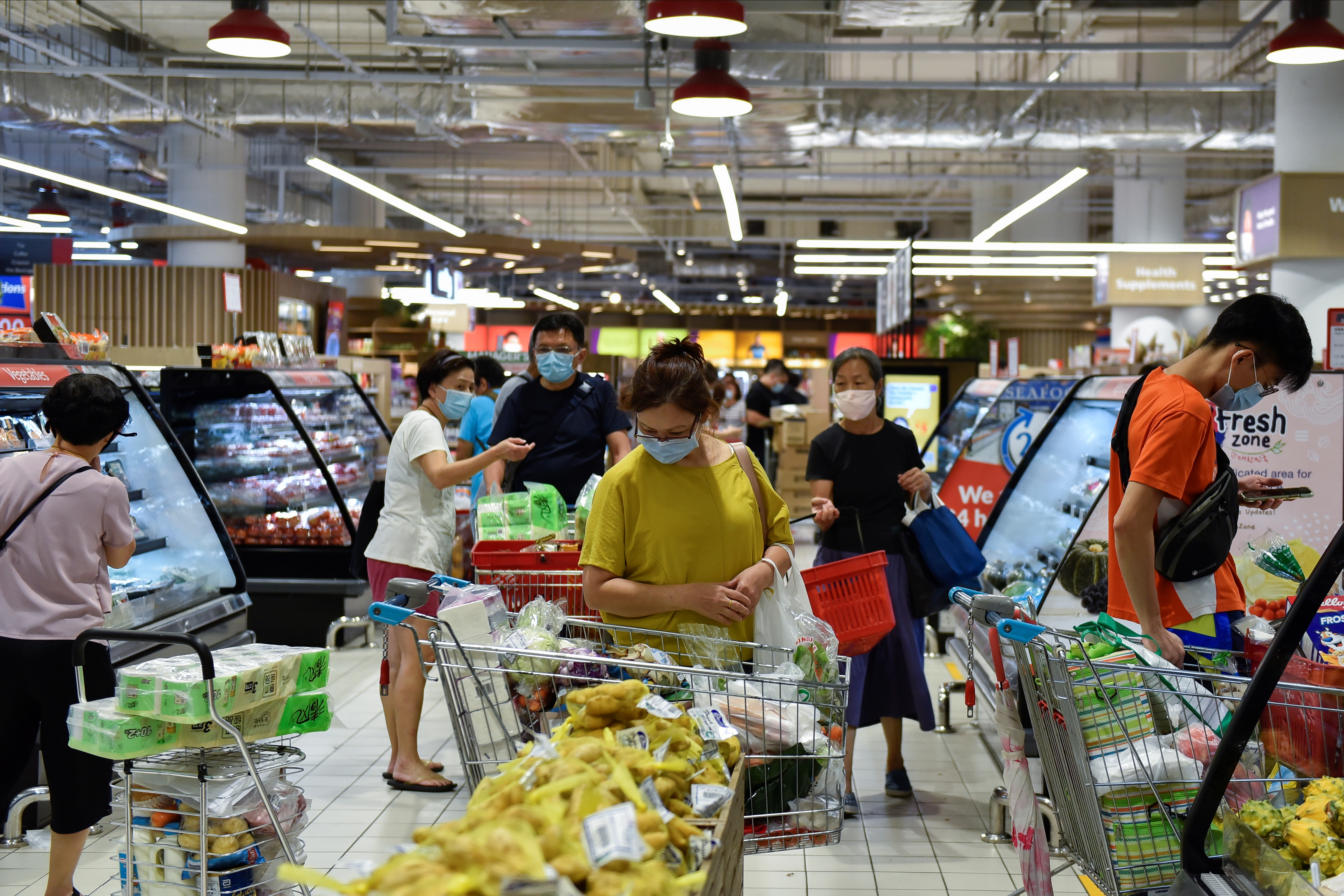 People shop for groceries at a supermarket after curbs on social gatherings and public activities were announced following a rise of coronavirus disease (COVID-19) cases in Singapore