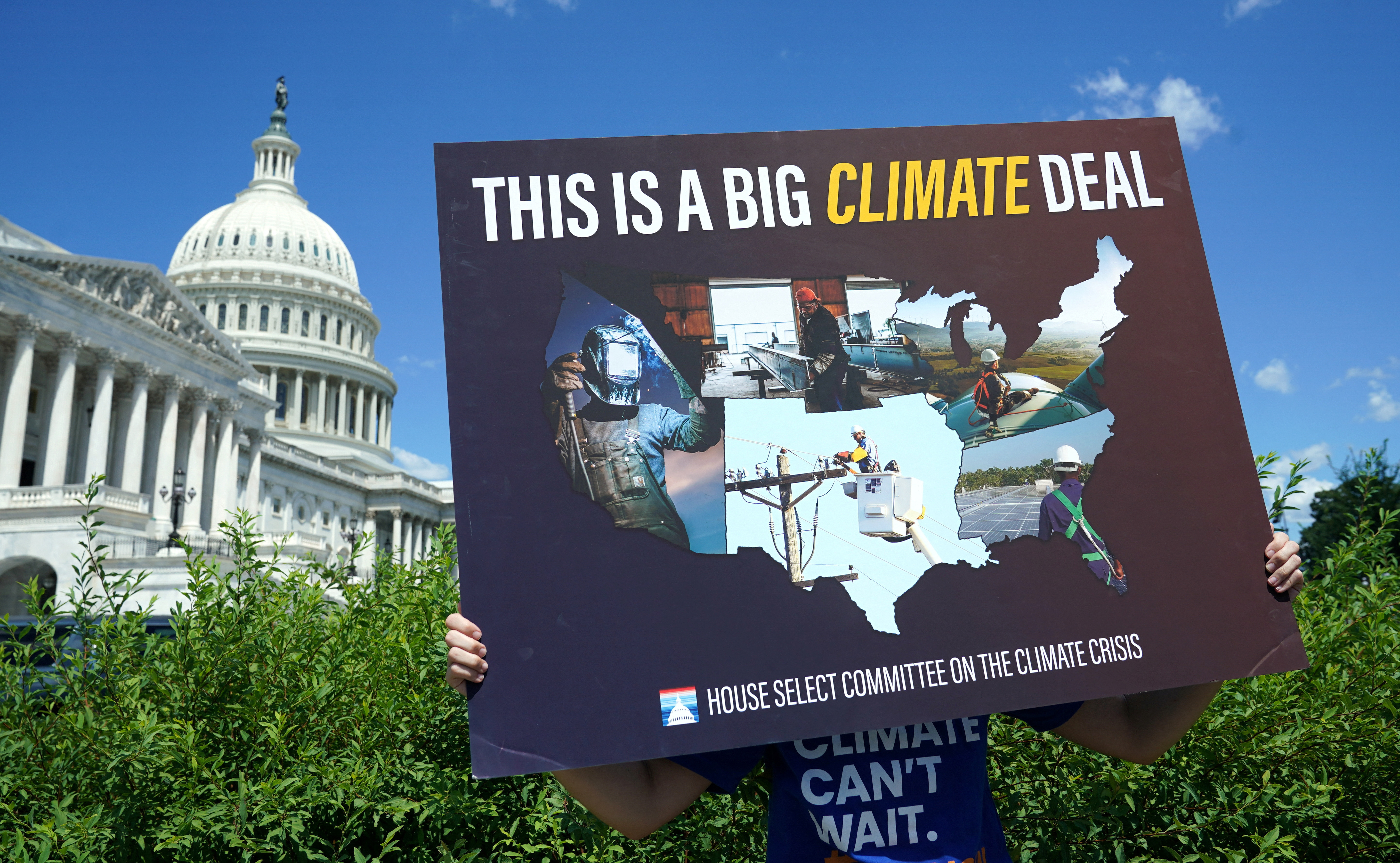 A placard is held during a climate crisis and Inflation Reduction Act press conference at the U.S. Capitol in Washington