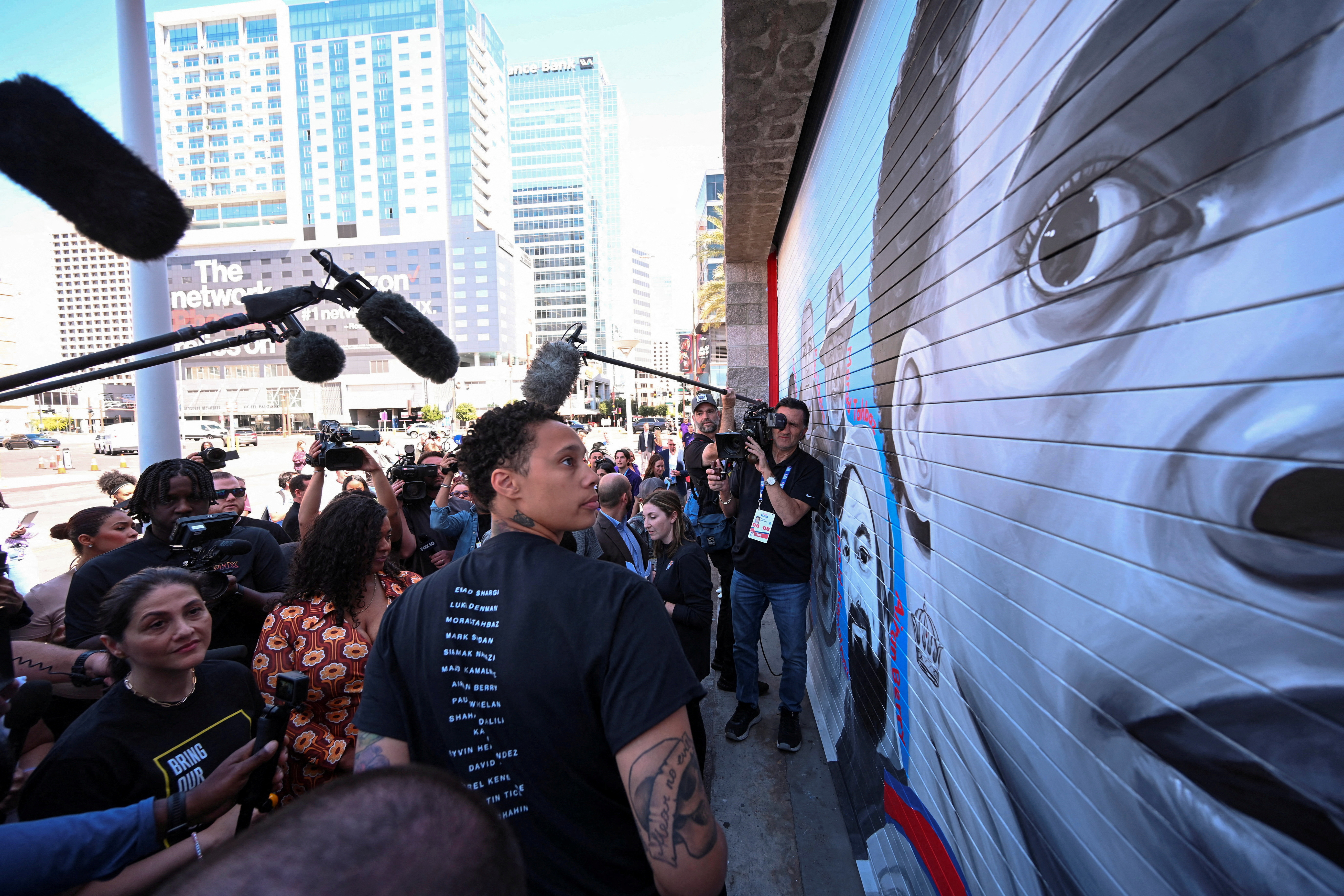 Brittney Griner unveils a mural painted by Antoinette Cauley, that depicts the faces of Griner and individuals who are detained oversees, in Phoenix, Arizona