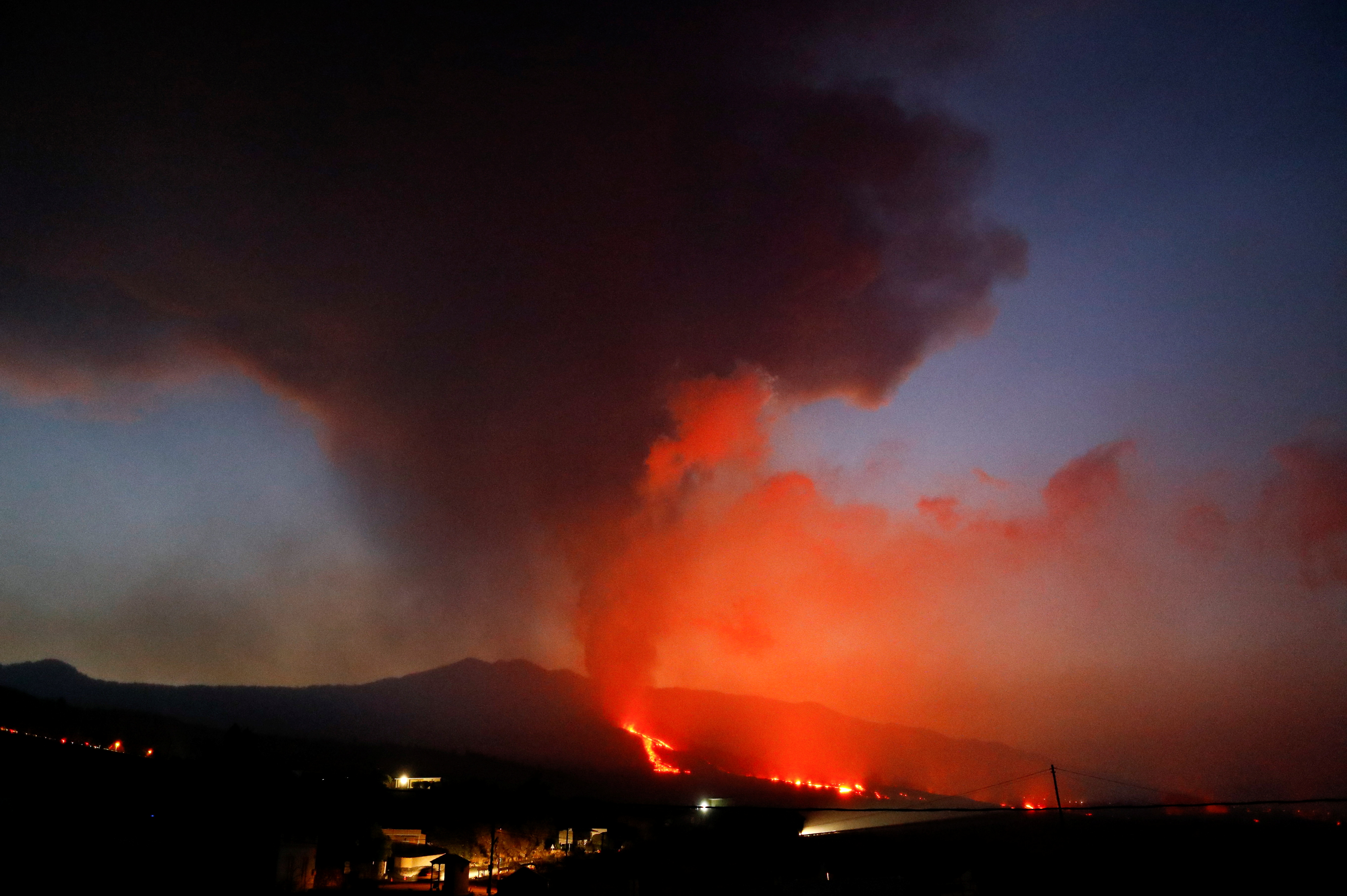 The Cumbre Vieja volcano spews lava and smoke while it continues to erupt, as seen from El Paso