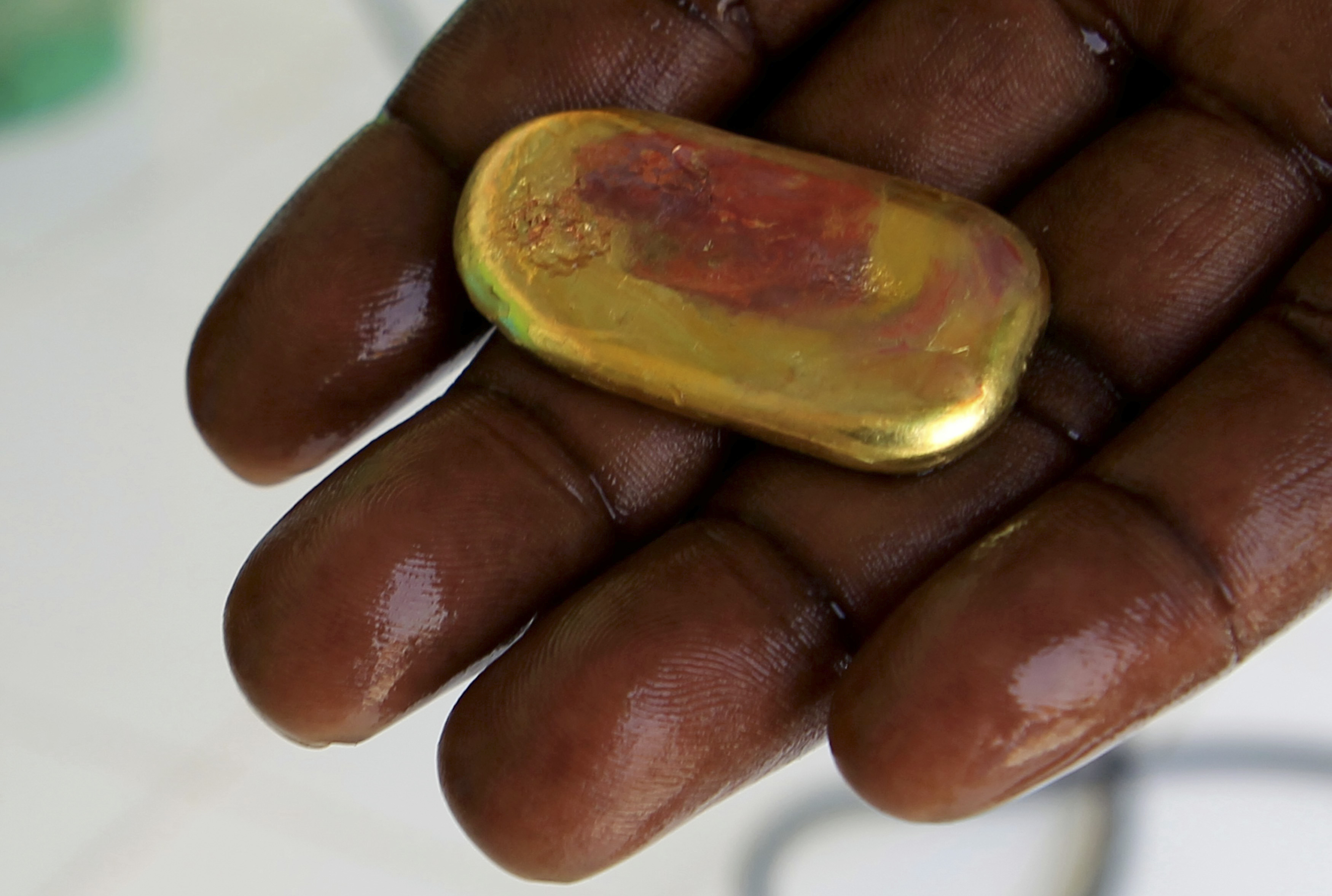 Trader shows a piece of gold at his shop in the town of Al-Fahir in North Darfur