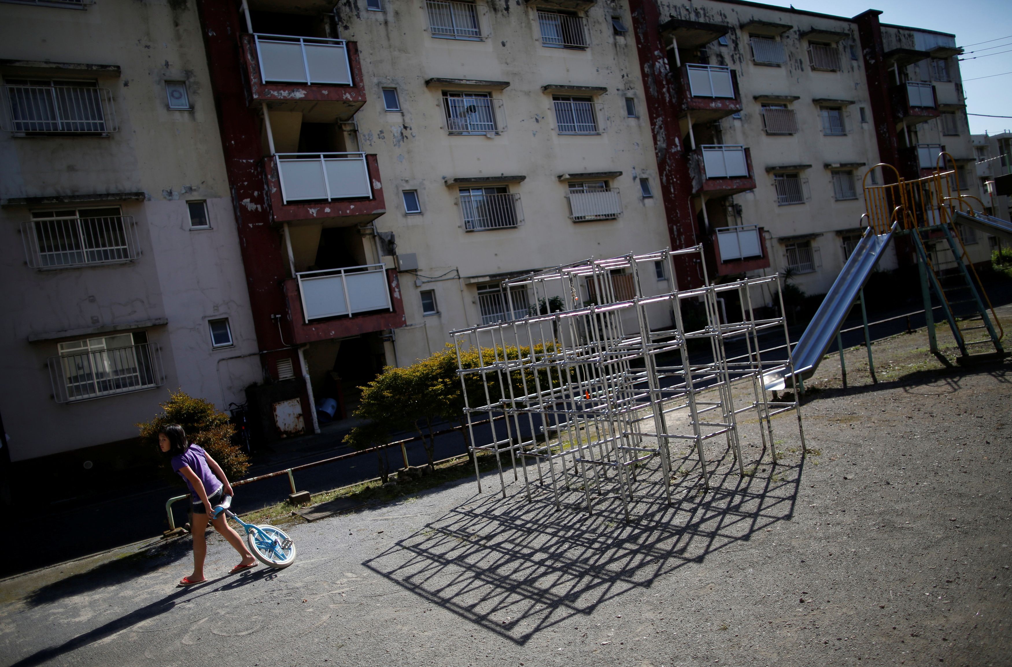 FILE PHOTO : A girl plays at a park inside the Kasumigaoka apartment complex, which is located near the National Olympic Stadium in Tokyo