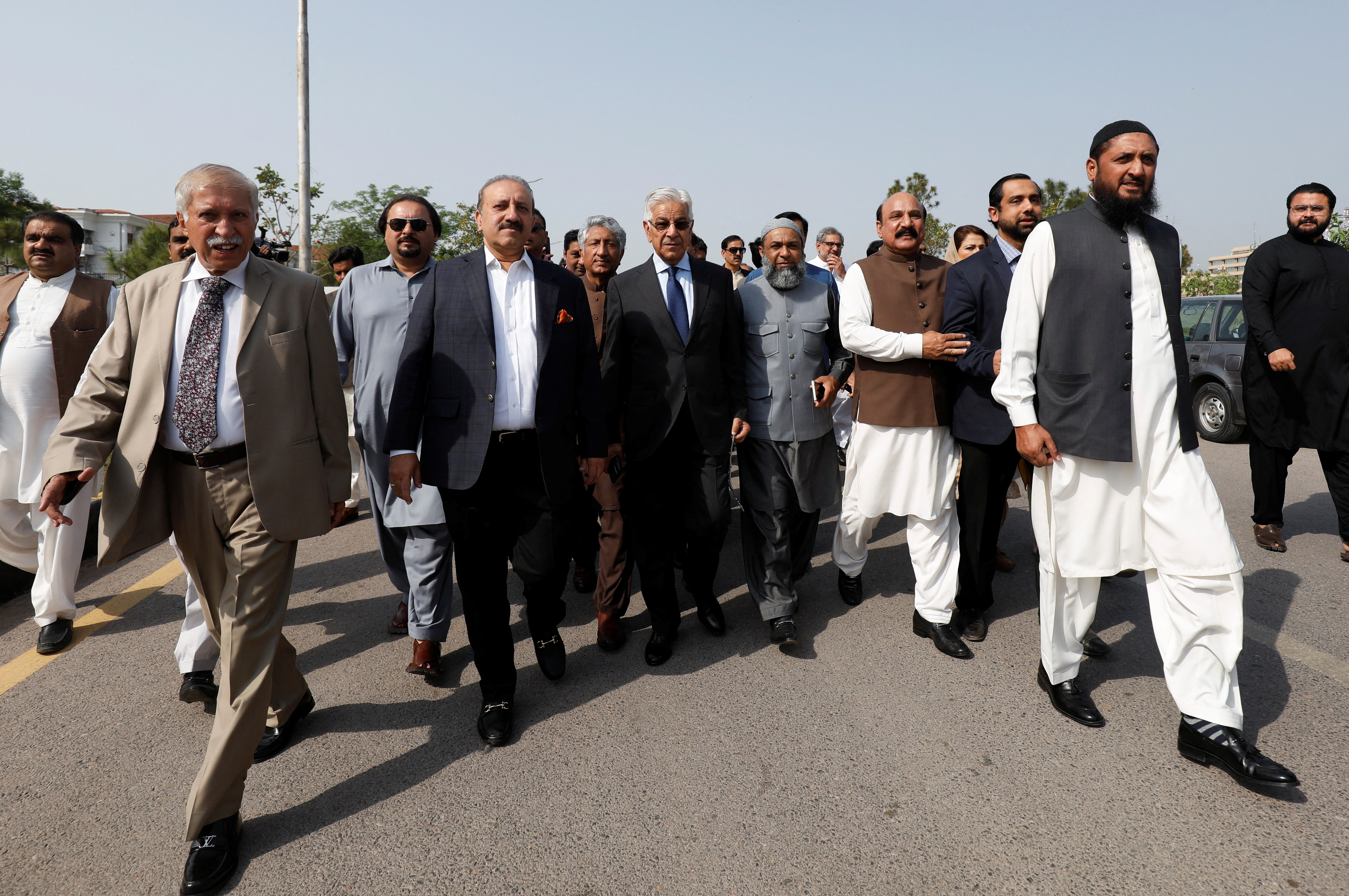 Pakistani lawmakers of the united opposition walk towards the parliament house building to cast their vote on a motion of no-confidence to oust PM Imran Khan, in Islamabad,