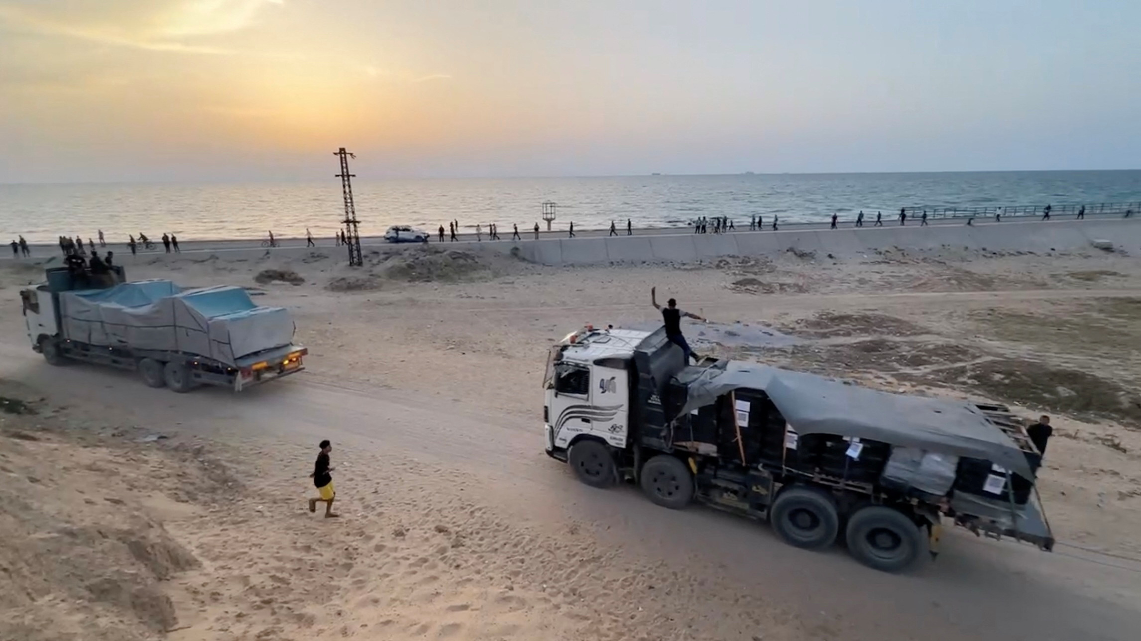 Trucks carrying aid delivered into Gaza via a U.S.-built pier move, as seen from central Gaza Strip