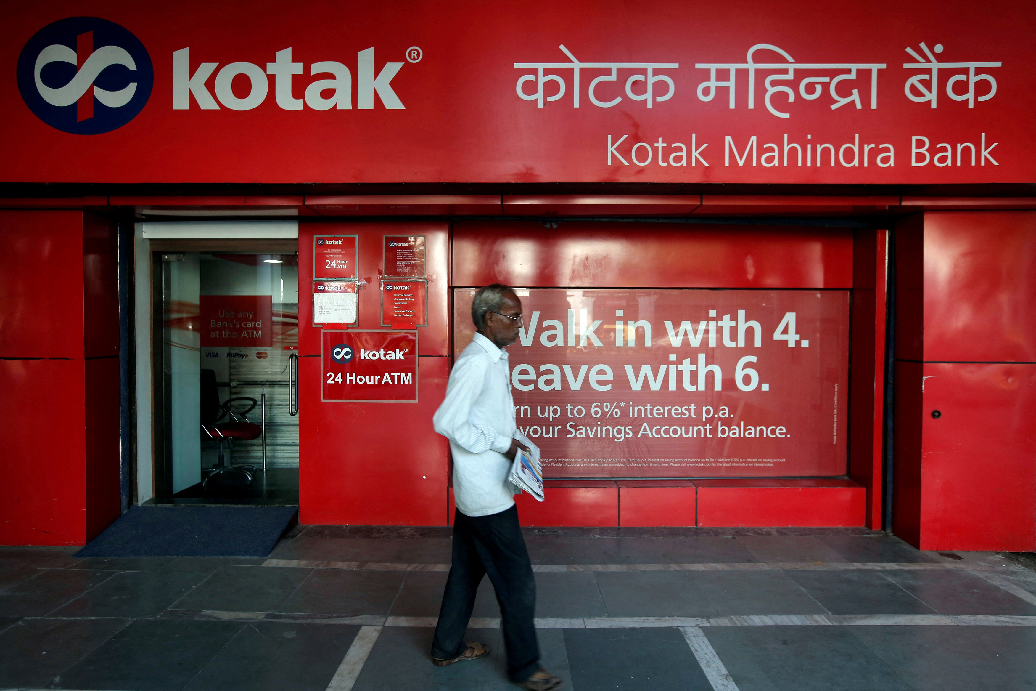 A man walks past the Kotak Mahindra Bank branch in New Delhi
