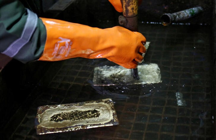 A worker cleans gold bars at South Africa's Gold Fields South Deep mine in Westonaria