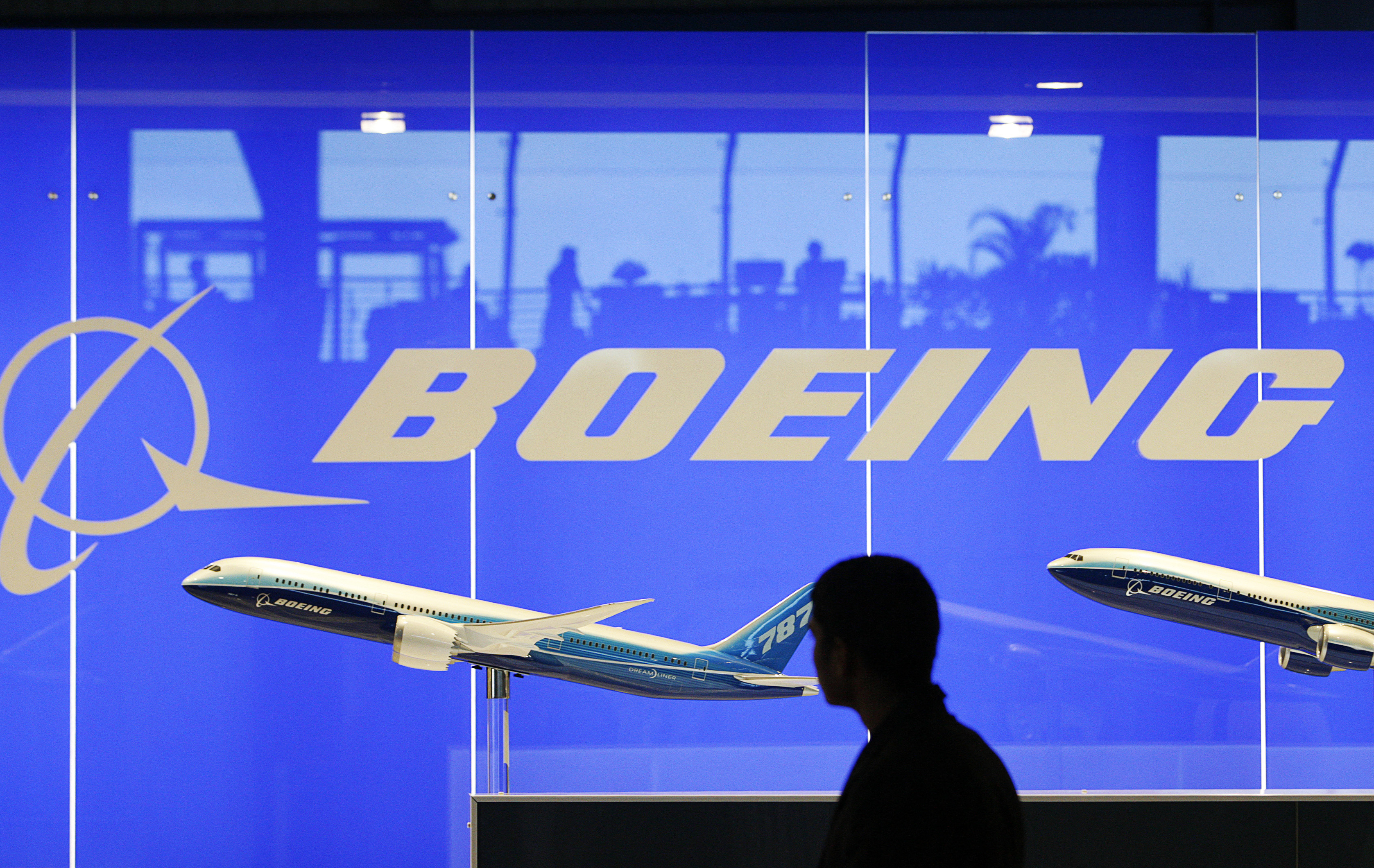 A man looks at a scale model of Boeing's 787 dreamliner at their booth at the Singapore Air Show in Singapore