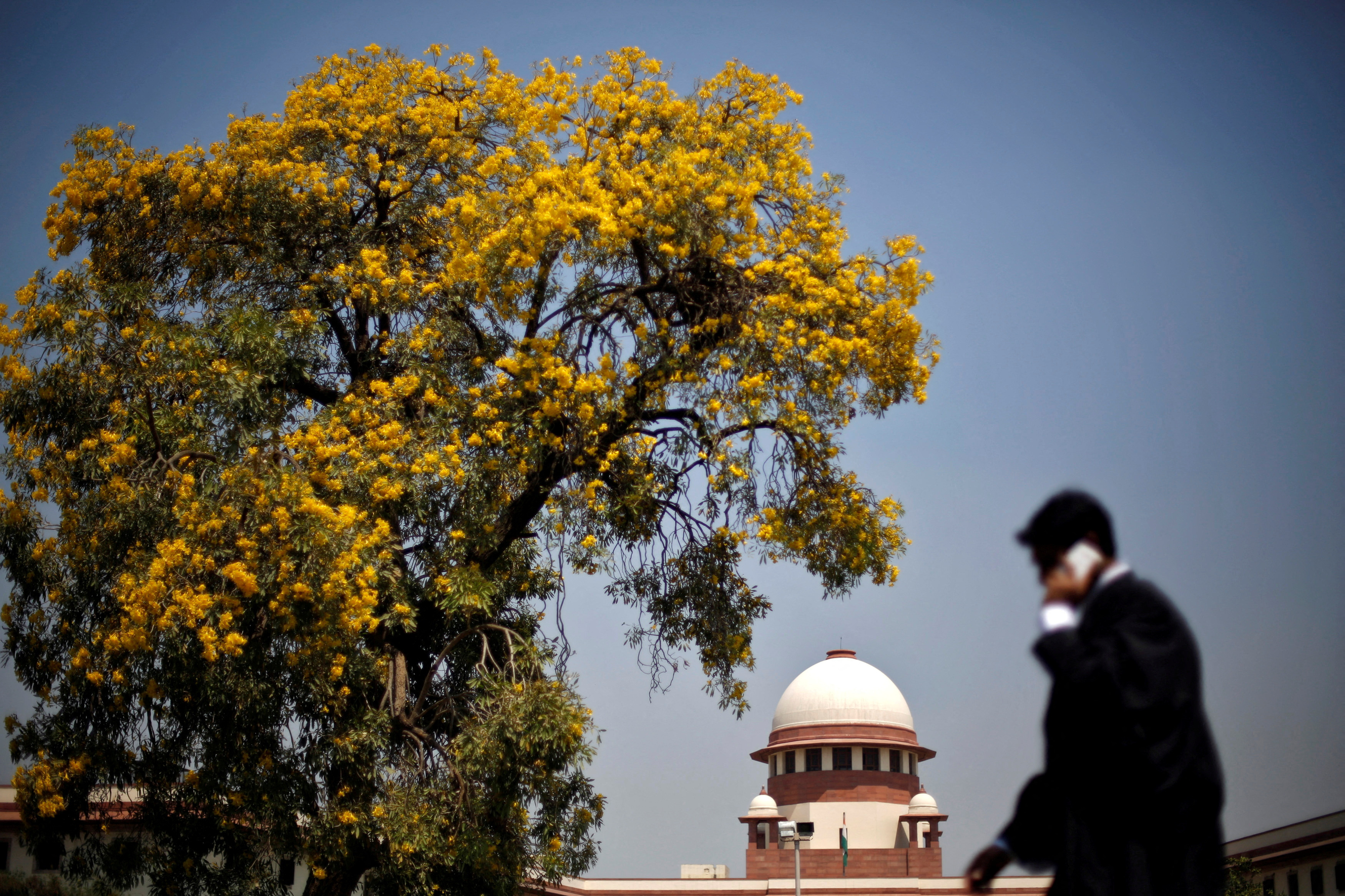 A Lawyer speaks on his mobile phone as he walks past India's Supreme Court in New Delhi