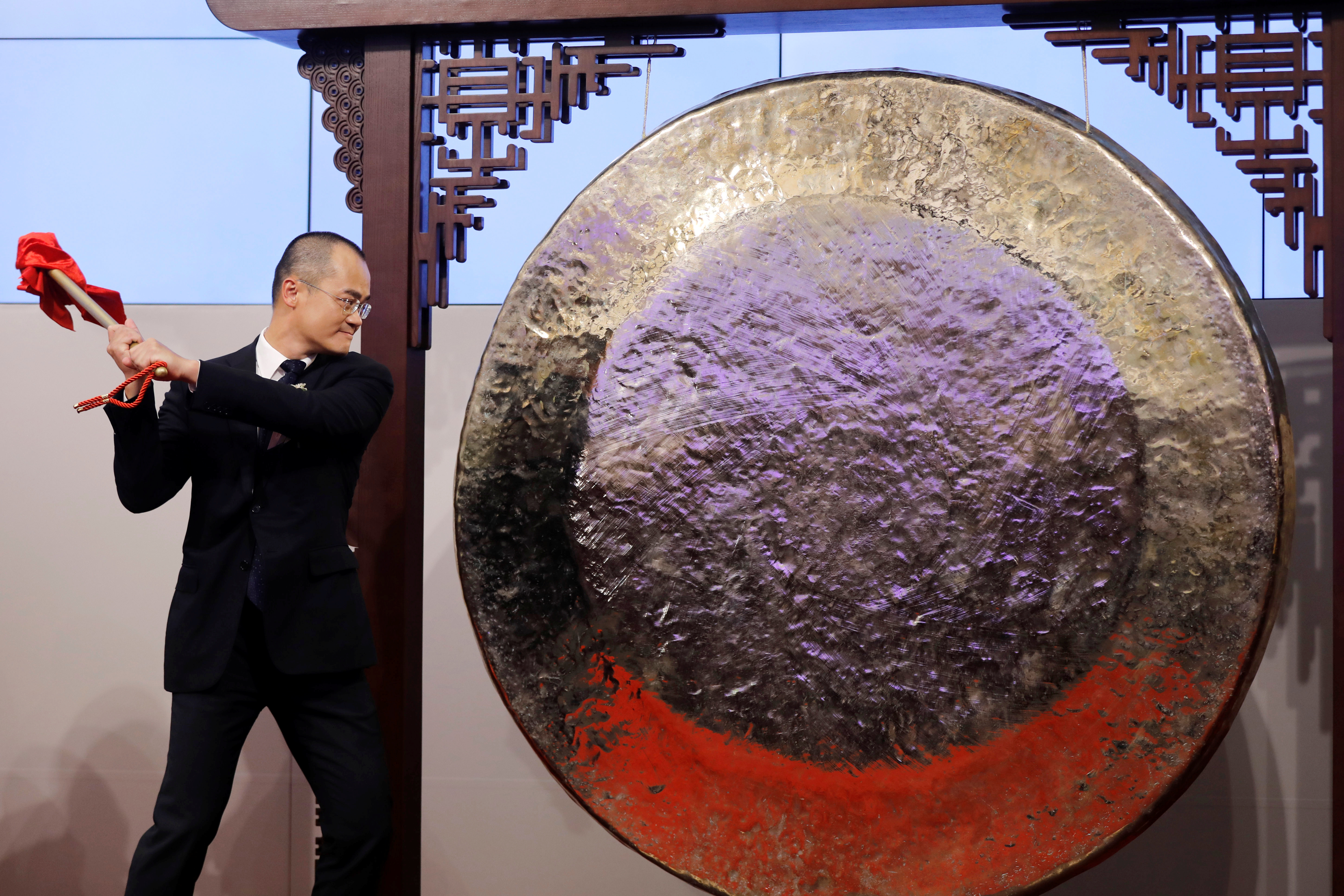 Meituan Dianping's Wang Xing hits the gong during the debut of the company at the Hong Kong Exchanges in Hong Kong