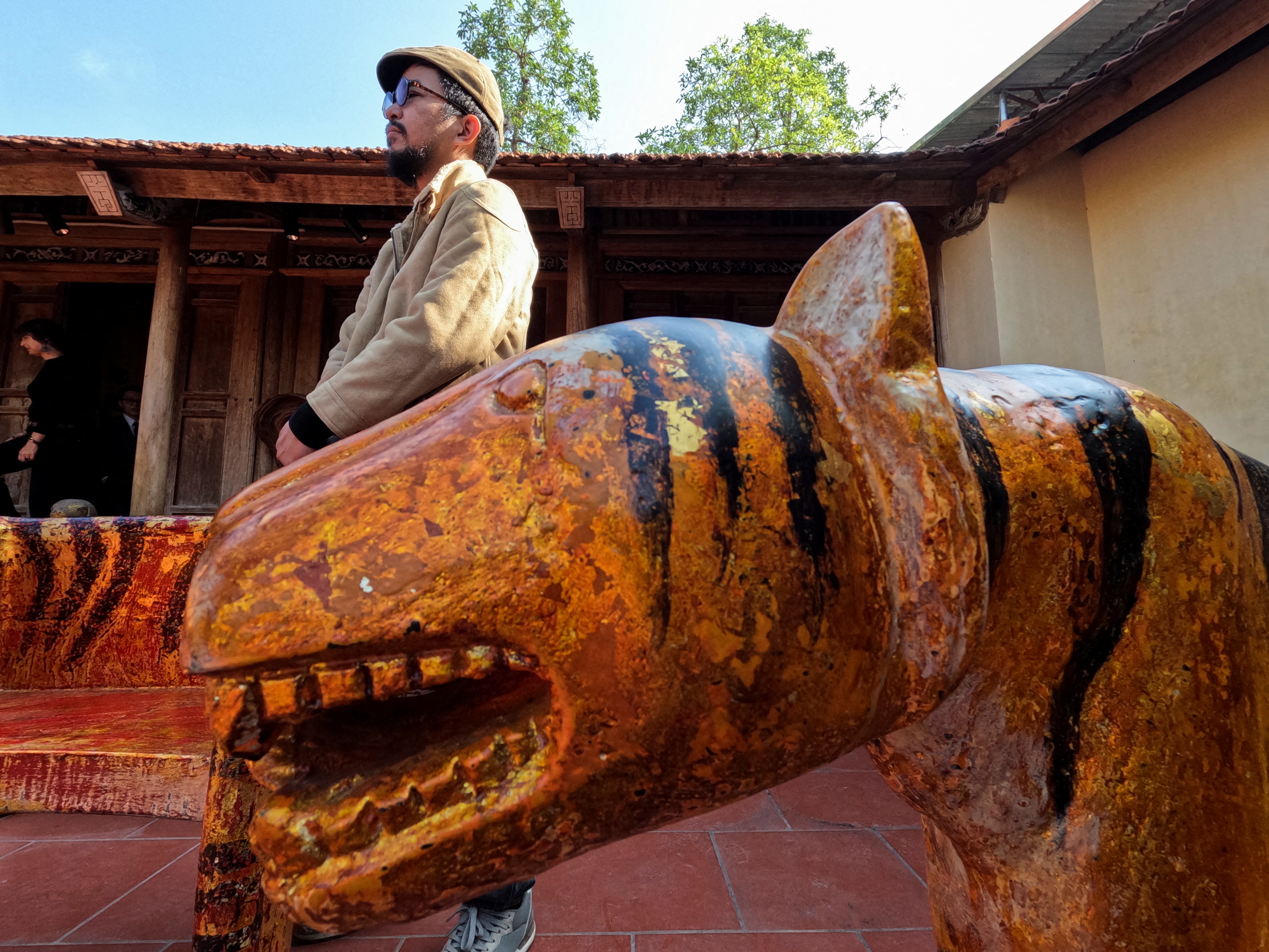 Nguyen Tan Phat stands in his yard with his Tiger carving works ahead of the Lunar New year in Hanoi