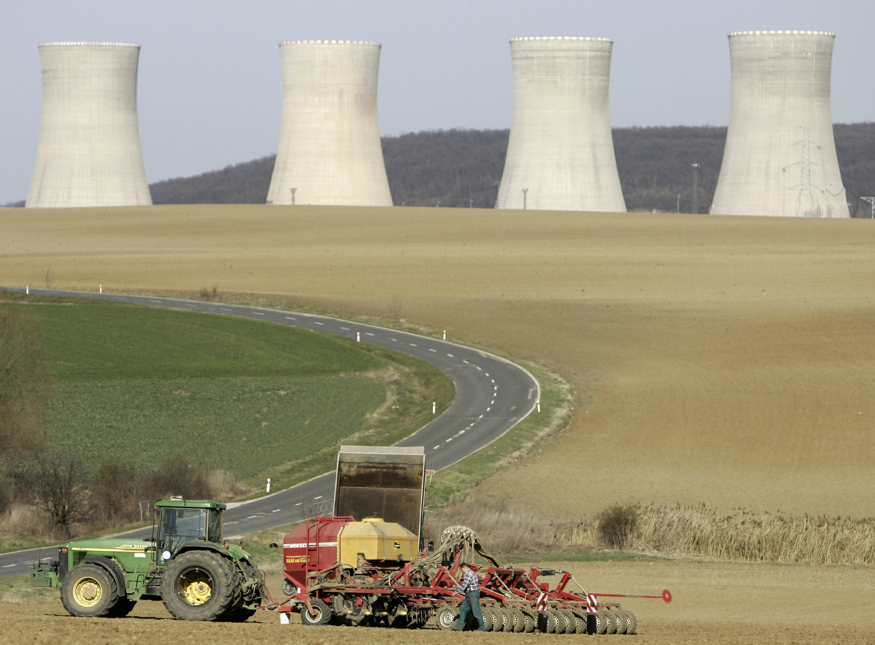 A farmer is seen in front of the Mochovce Nuclear Power Plant cooling towers in Mochovce