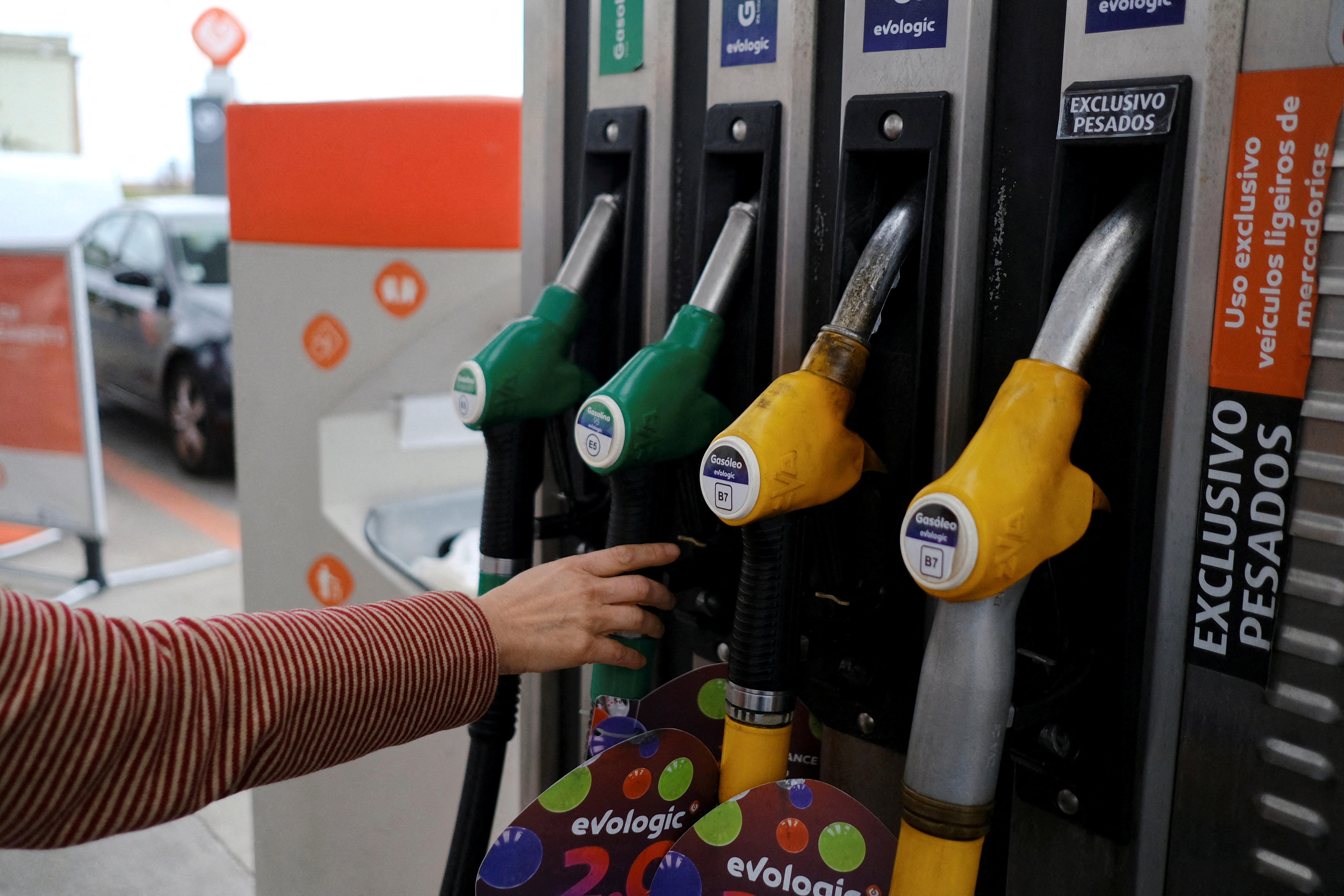 A person uses a petrol pump, as the price of petrol rises, in Lisbon