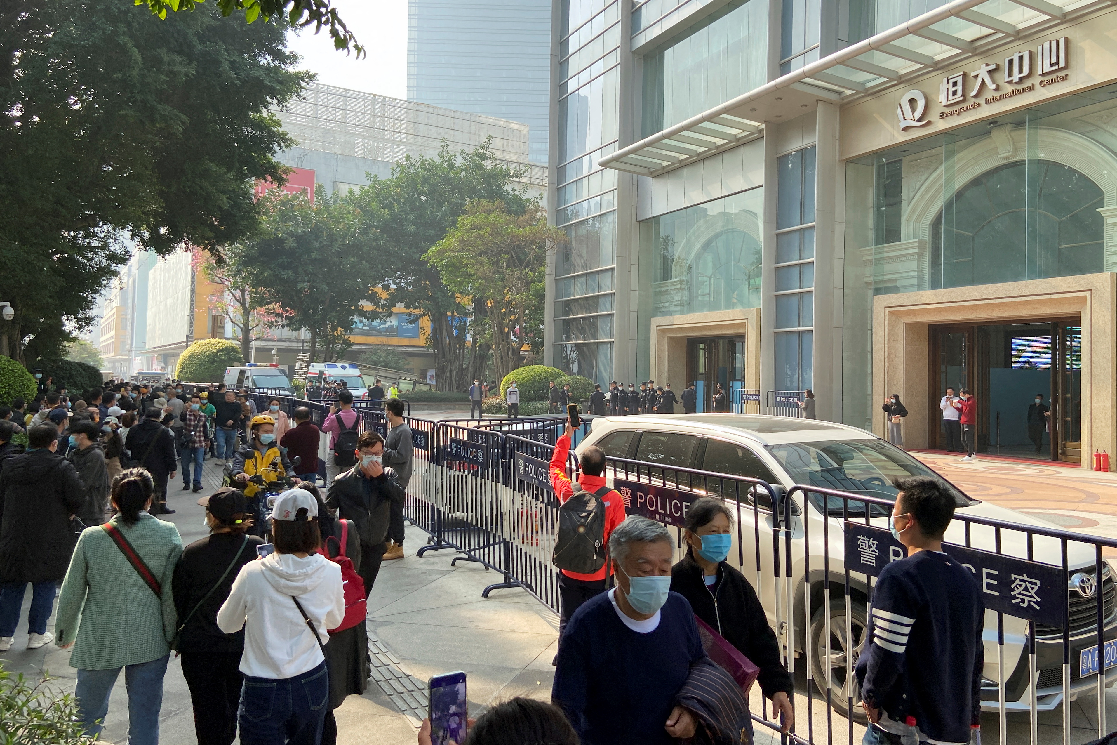 Protesters and police officers outside the Evergrande International Center in Guangzhou