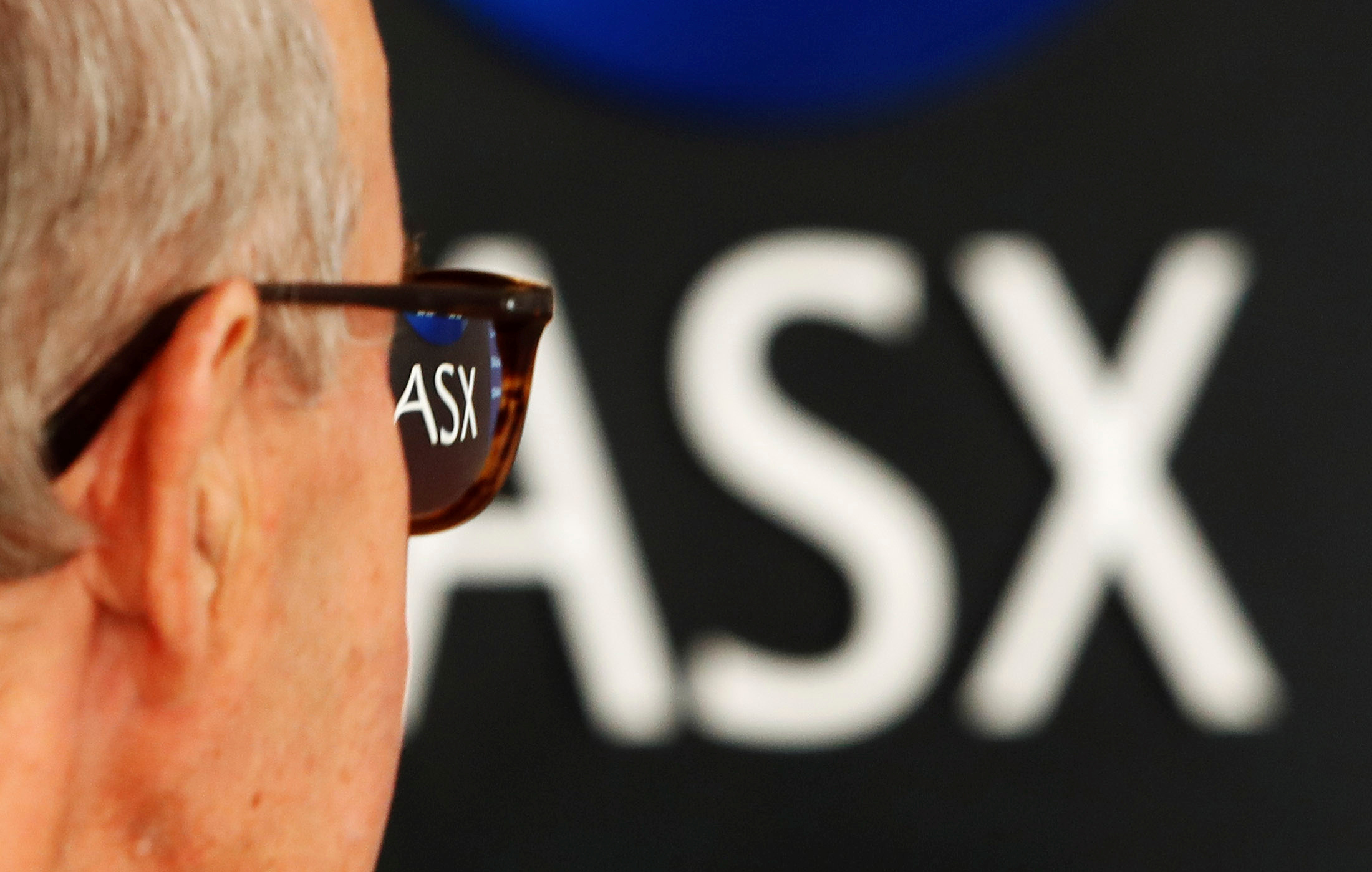 A man looks at the main board at the Australian Securities Exchange building in central Sydney