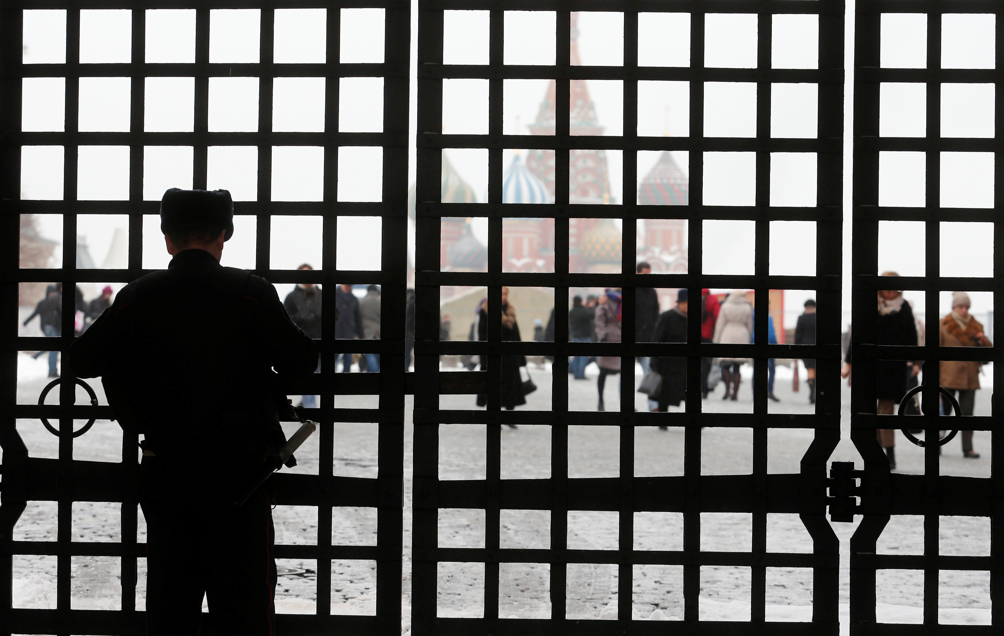 Interior Ministry officer closes gate near Red Square and Basil's Cathedral in Moscow