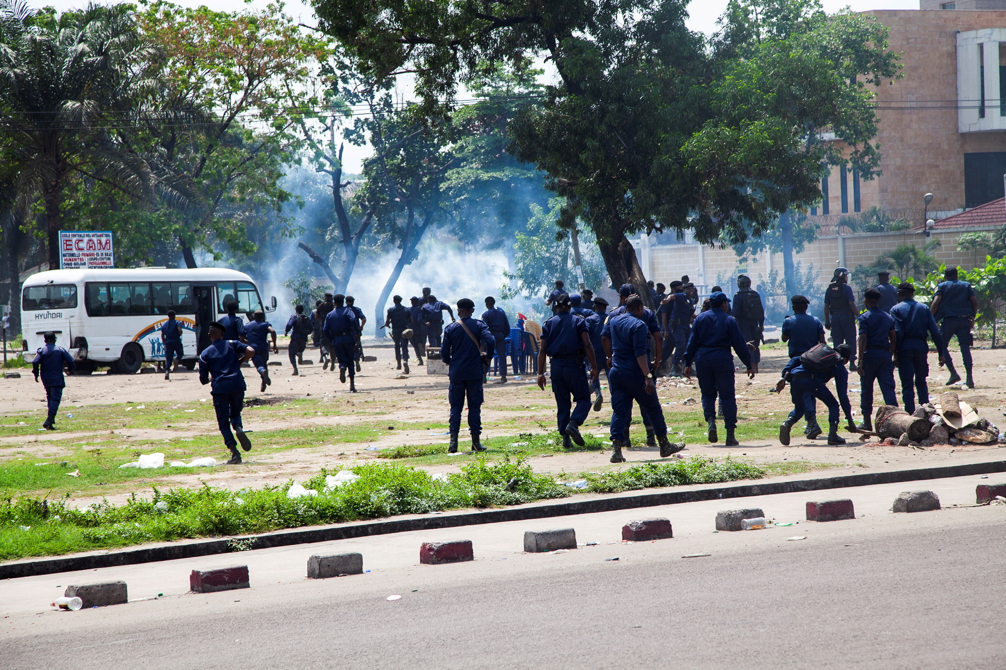 Police rush to stop rival political supporters fighting during a protest by followers of opposition leader Martin Fayulu who were demonstrating the independence of the country’s electoral commission, in Kinshasa