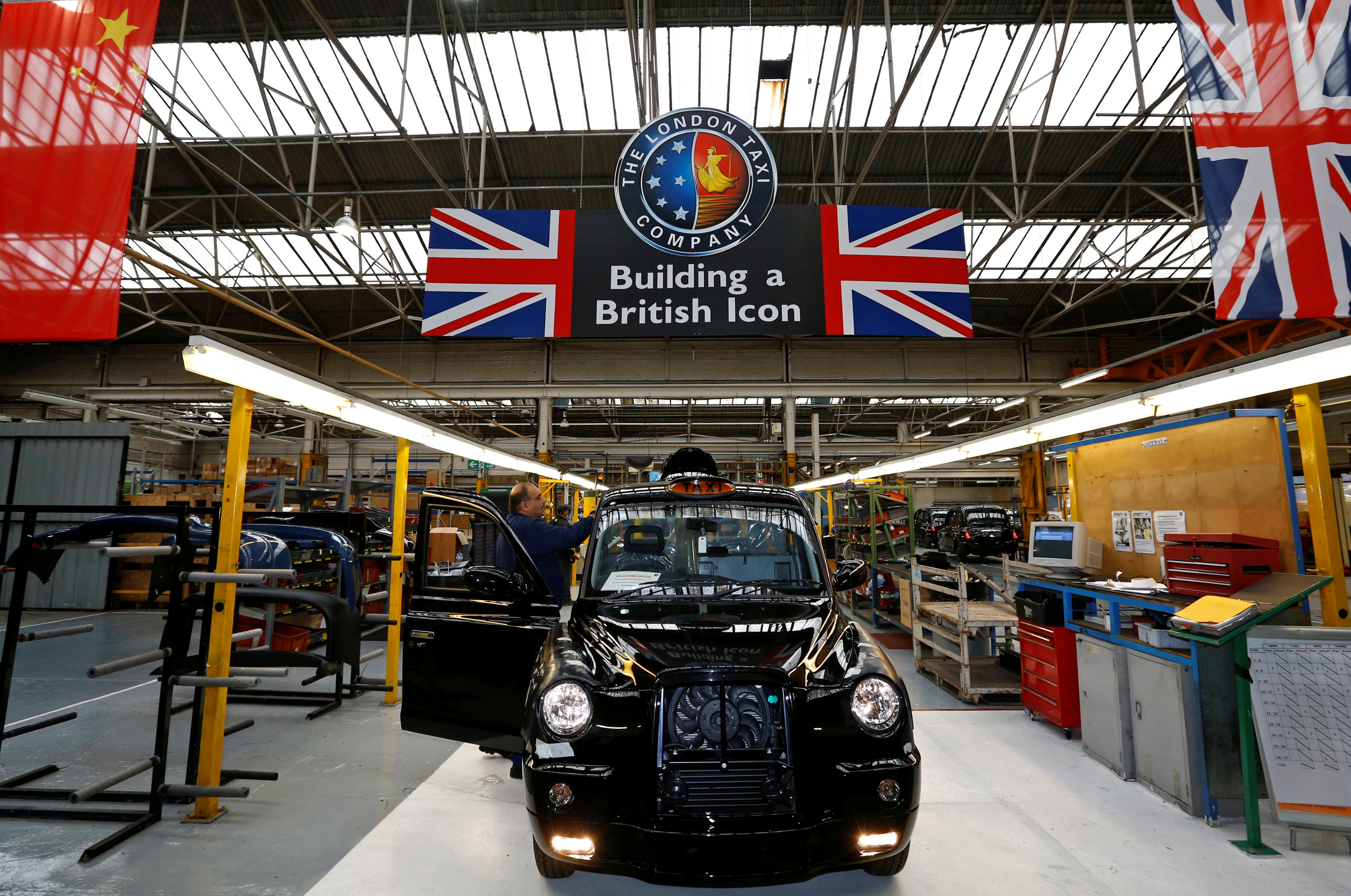 A worker checks a TX4 at the end of the production line at the London Taxi Company in Coventry