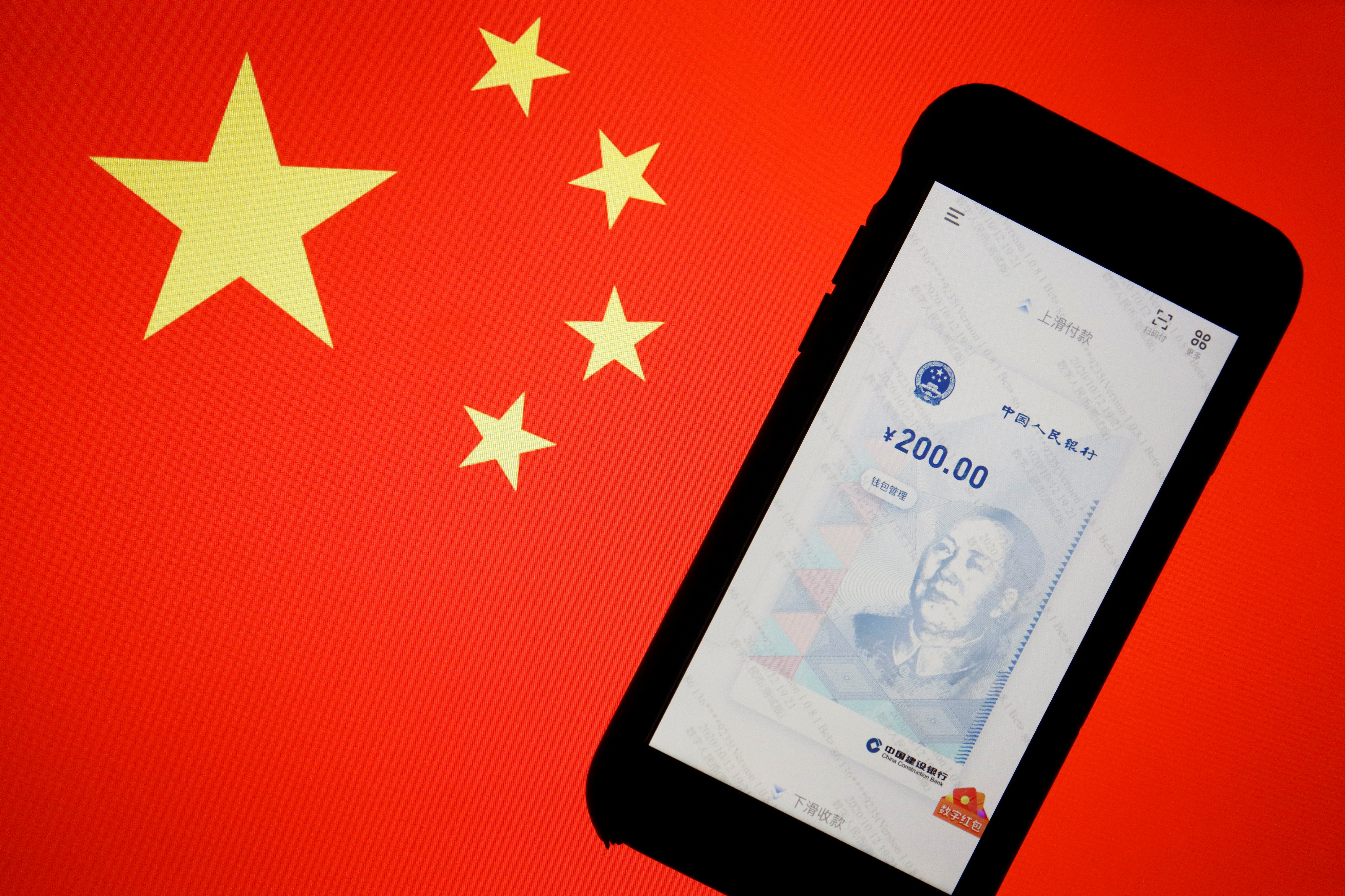China's official app for digital yuan is seen on a mobile phone placed in front of an image of the Chinese flag, in this illustration. REUTERS/Florence Lo/Illustration